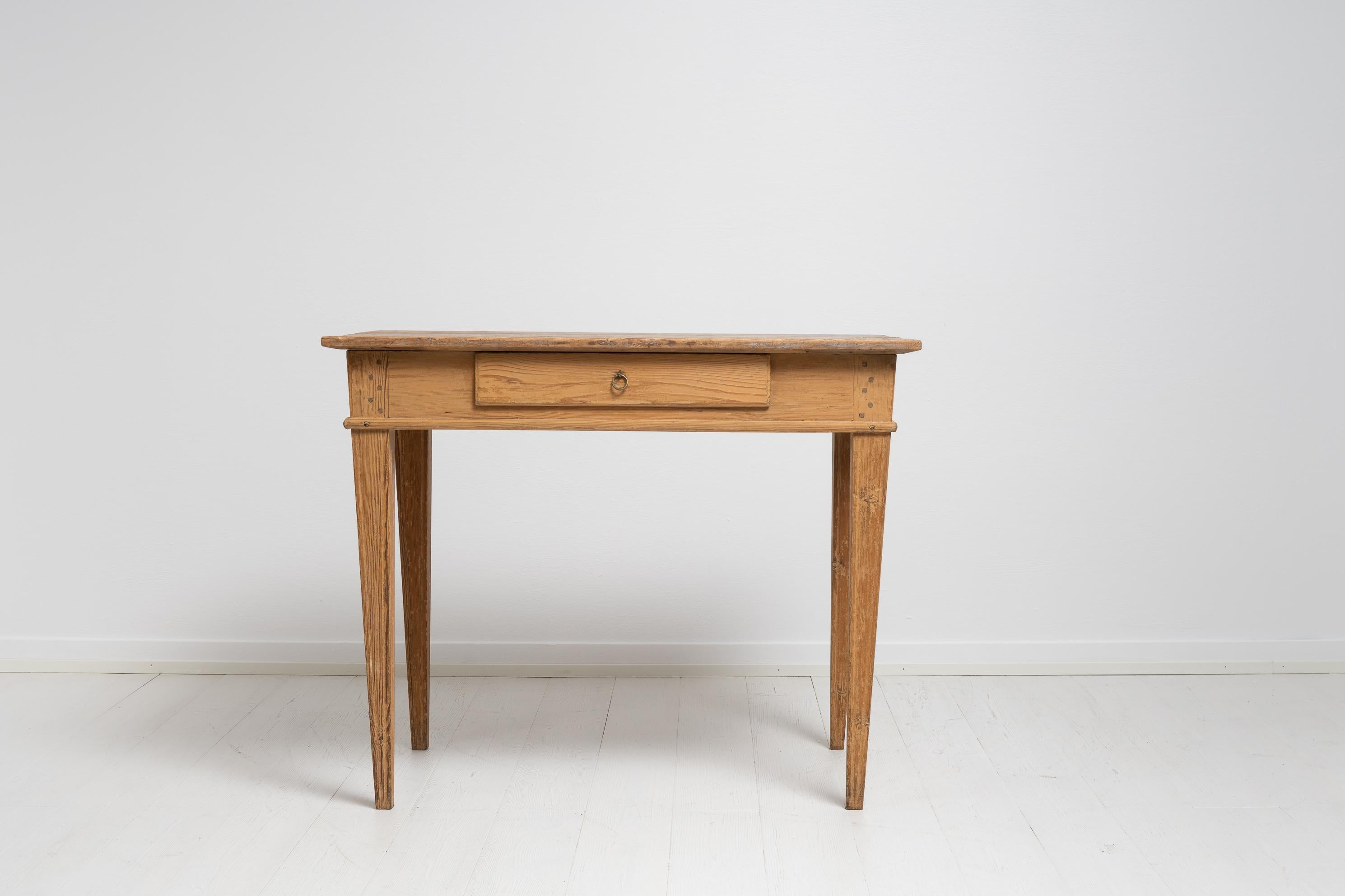Northern Swedish gustavian country home desk made during the early 19th century, between 1810 and 1820. The desk is a genuine country home furniture and has tapered legs with hand carved flutes and a drawer in the rim. Simple and functional with