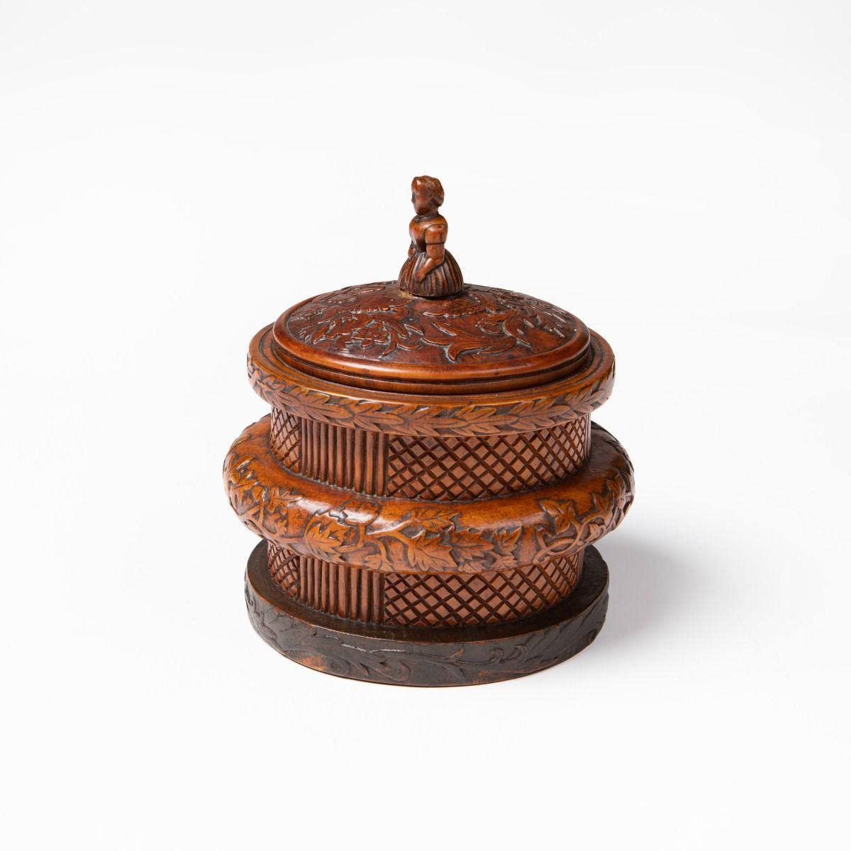 Folk art: Norwegian lidded box (butter box) crafted in birch with rich woodcarving.
The lid finial carved as a seated woman.
Lid and rim decorated with reliefs of oak leaves, acorns, and stylised foliage.
The box has a beautiful natural patina and