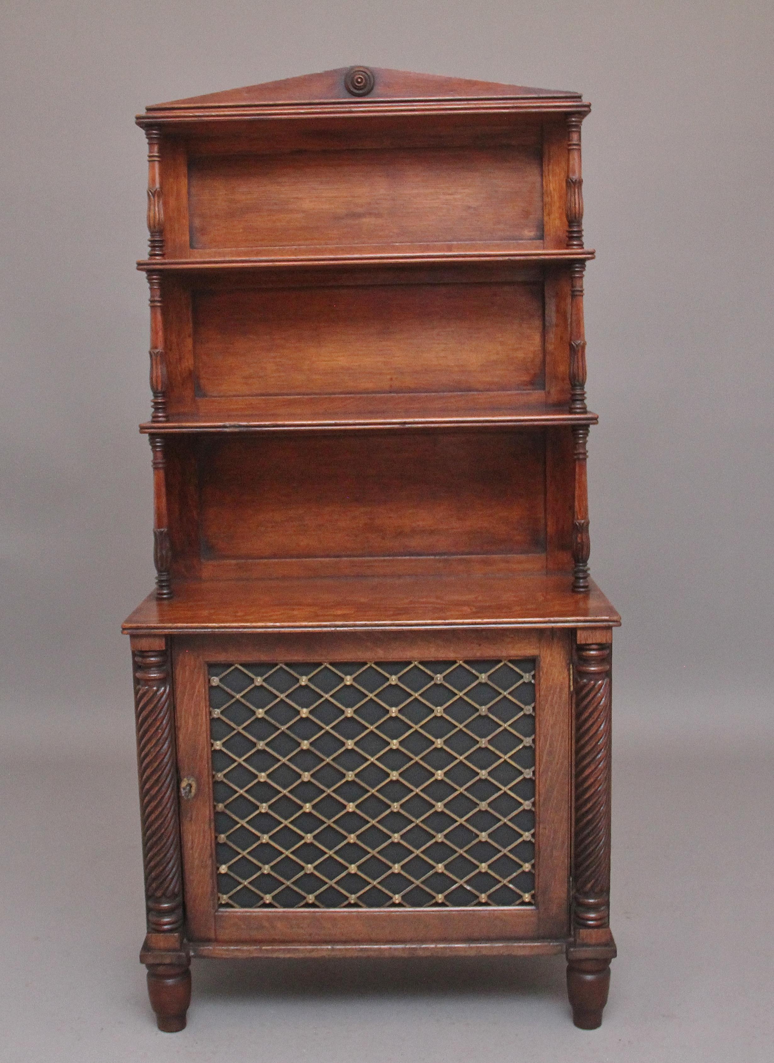 19th century oak bookcase cabinet of nice proportions, the arched cornice above three shelves with reeded edges supported by finely turned and carved columns, with a panelled back, the bottom section having a hinged cupboard door with decorative