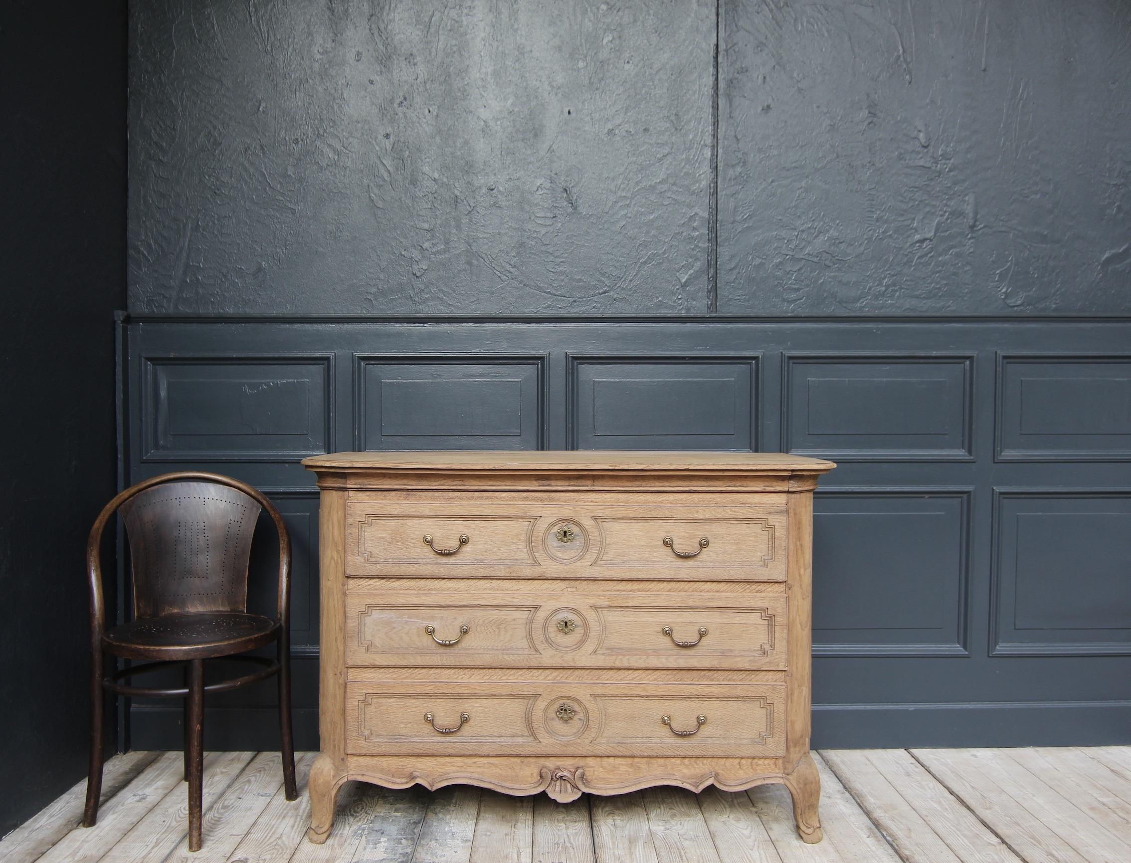 Una cassettiera di provincia dell'inizio del XIX secolo realizzata in rovere massiccio. 

Corpo in Oak a cassettoni laterali con tre cassetti, angoli arrotondati e pannello superiore sagomato in tinta. Cornice a plinto sagomato a più curve con