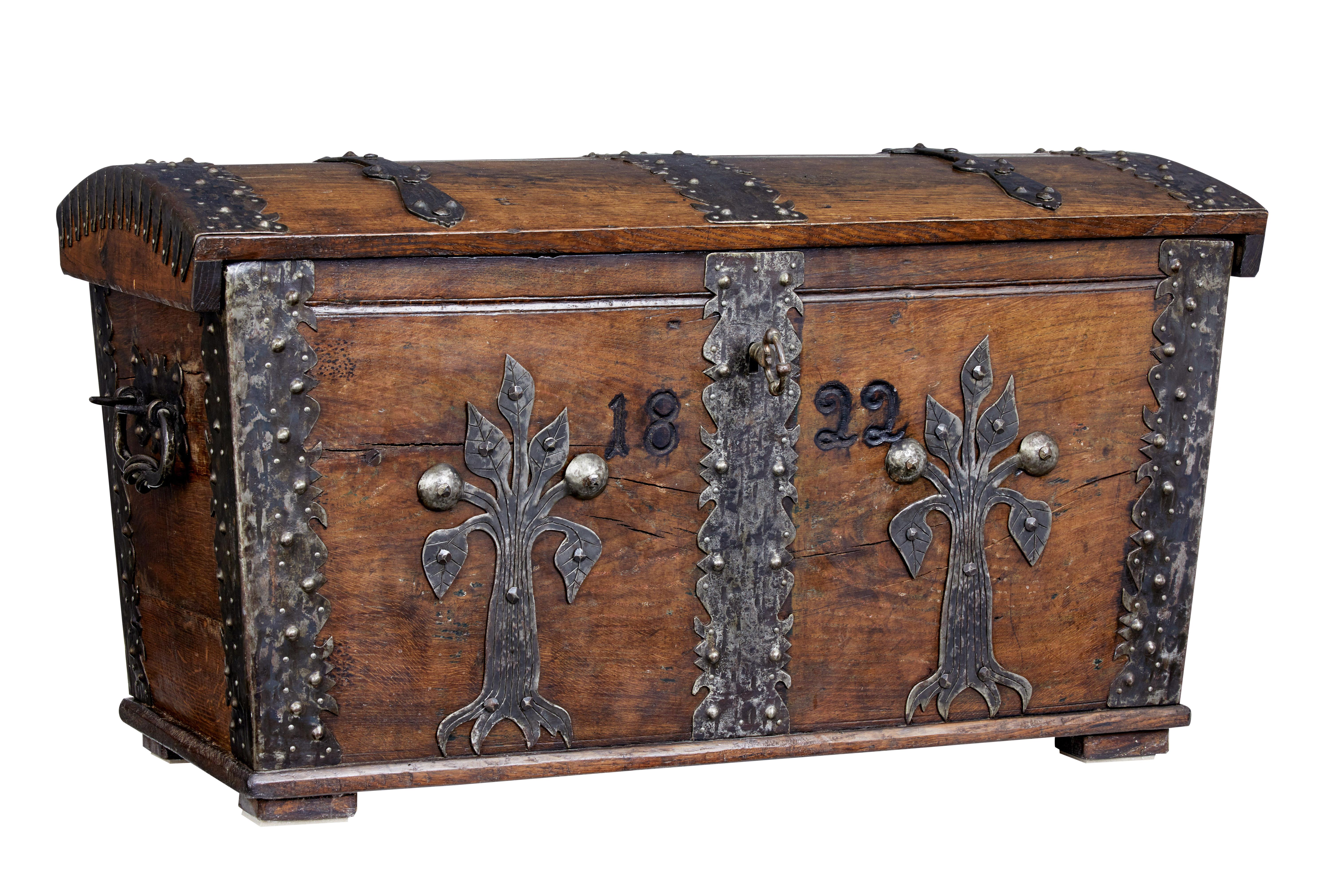 Decorative oak trunk, circa 1820.

Dome top with decorative strap work. Hand carved on the front with the year 1822, with further floral metal work. Matched metal work to corners with iron carry handles.

Lid opens for storage space, with fitted