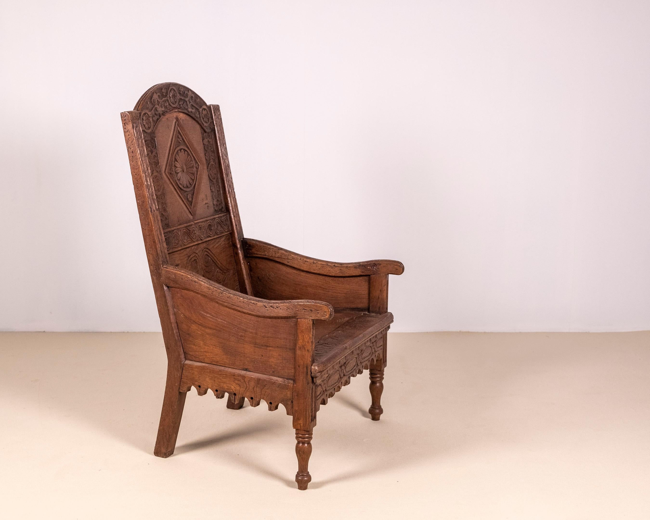 Sillón de arrimadero de roble de principios del siglo XVIII, de estilo Tudor. Fantásticas vetas de madera en los paneles, la carpintería y las tallas de roble; el respaldo tiene maravillosas tallas florales, incluso la parte superior de los