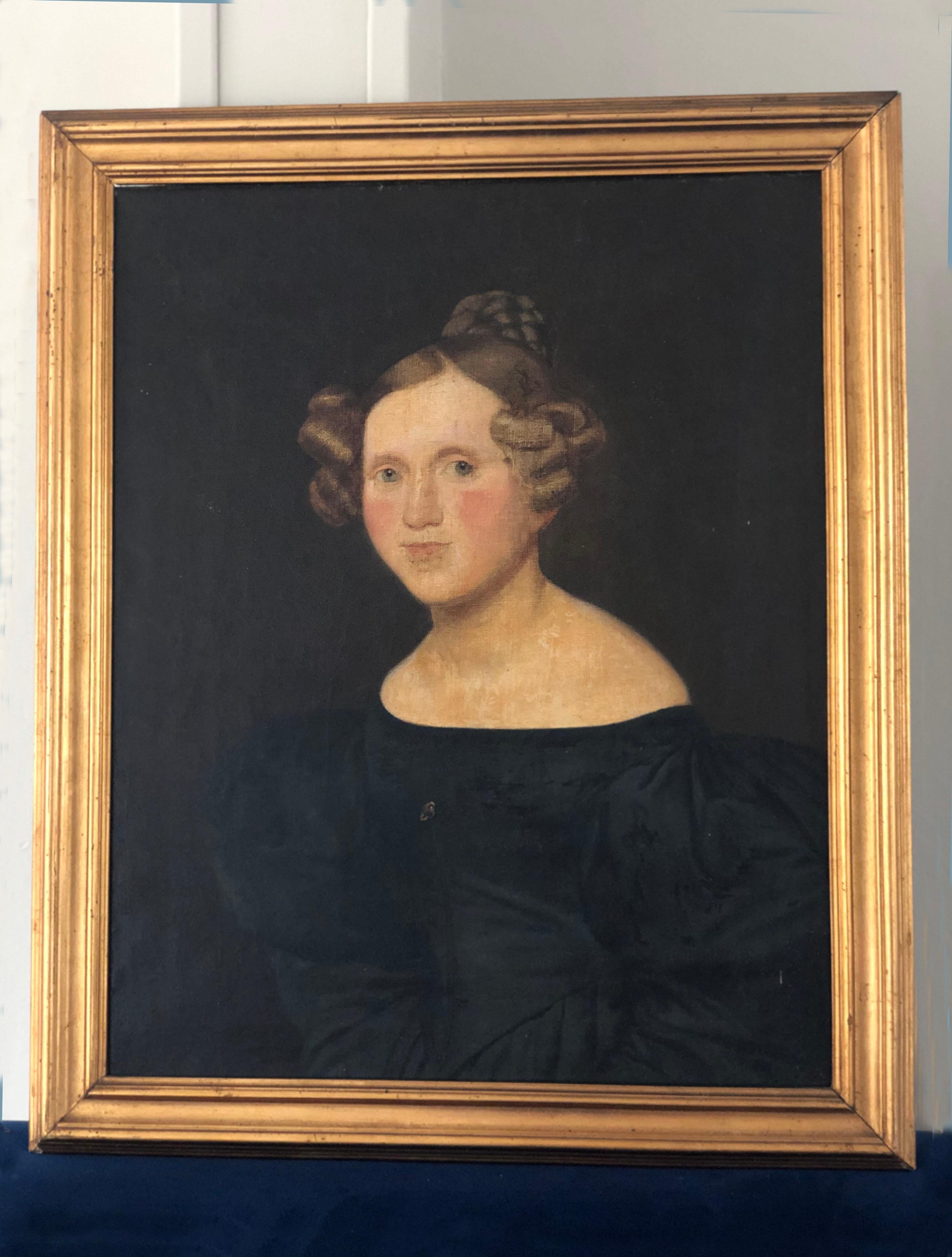 This oil painting captures the essence of a distinguished Danish woman from the early 19th century. The painting has a beautiful dark background, which lets the gilded frame stand out. 
On the back of the frame there are several names and dates