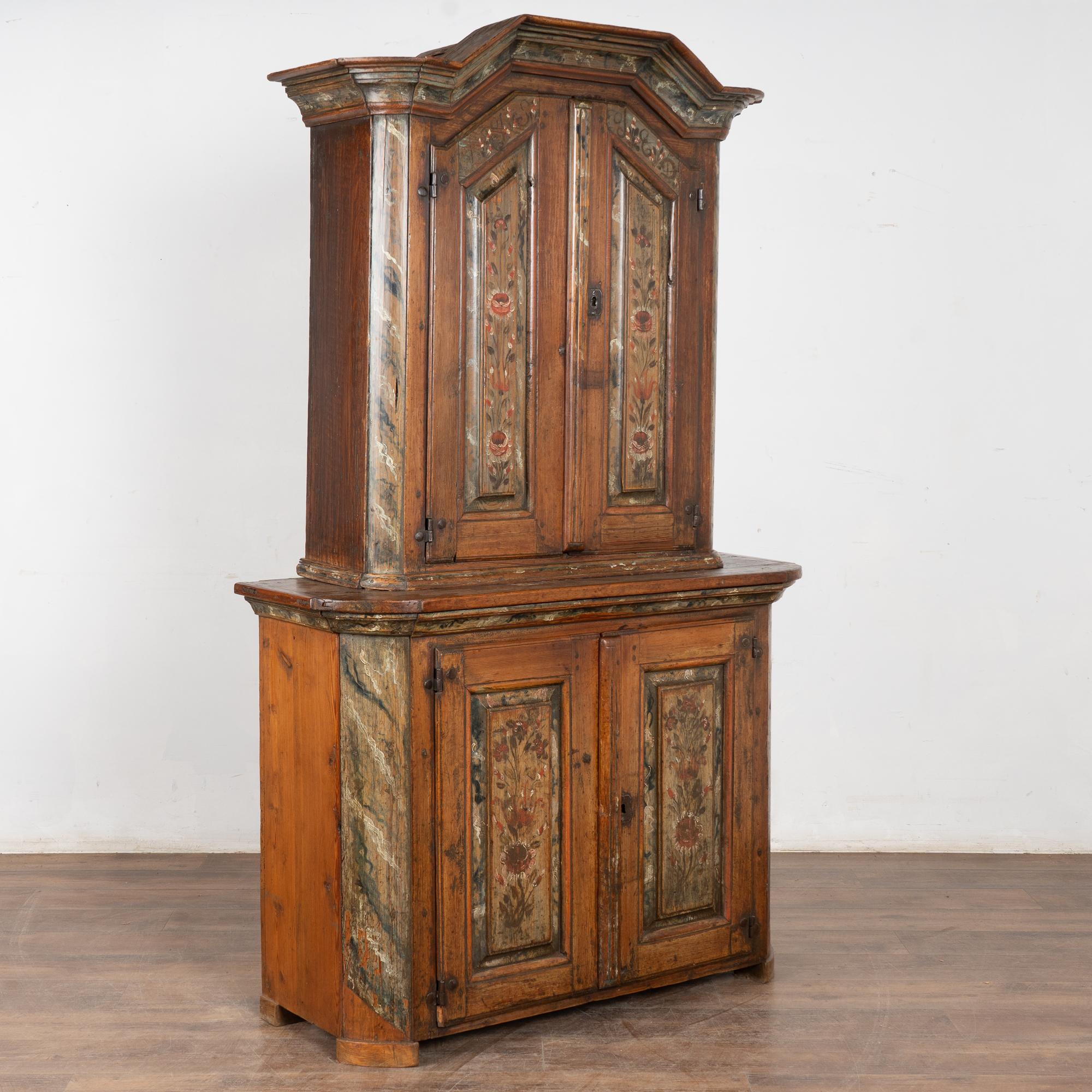 Cette armoire en pin est un exemple remarquable de l'artisanat suédois et d'une peinture folklorique originale. La patine profonde du pin est le résultat de nombreuses générations d'utilisation.
Les panneaux de porte et la couronne sont ornés de
