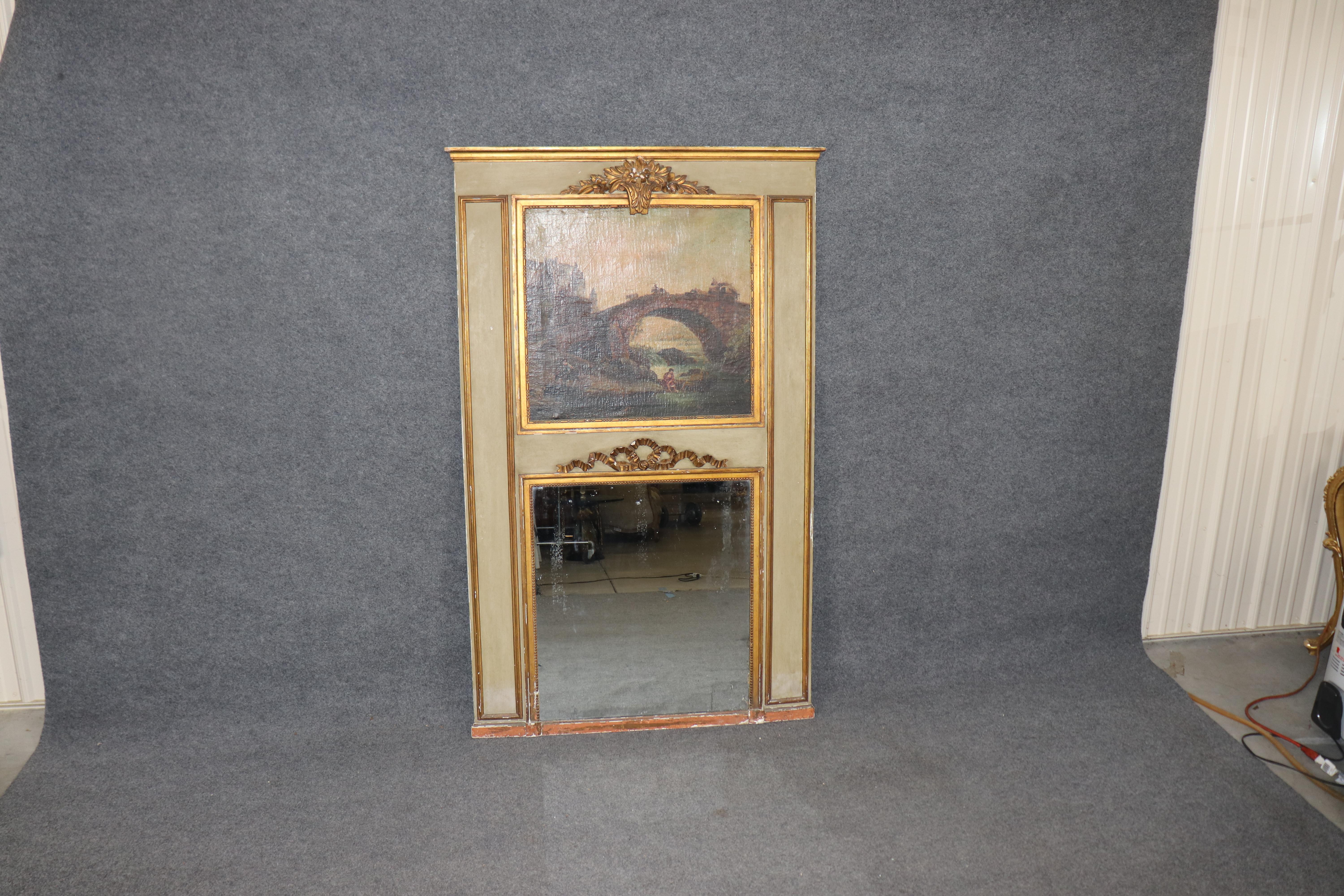This is a fantastic oil painting within a fine paint decorated and gilded frame Trumeau mirror from the 1840s era. The frame is gilt and a green color and features a depiction of a hrose and carriage, a love-lorn woman sitting by herself and life in