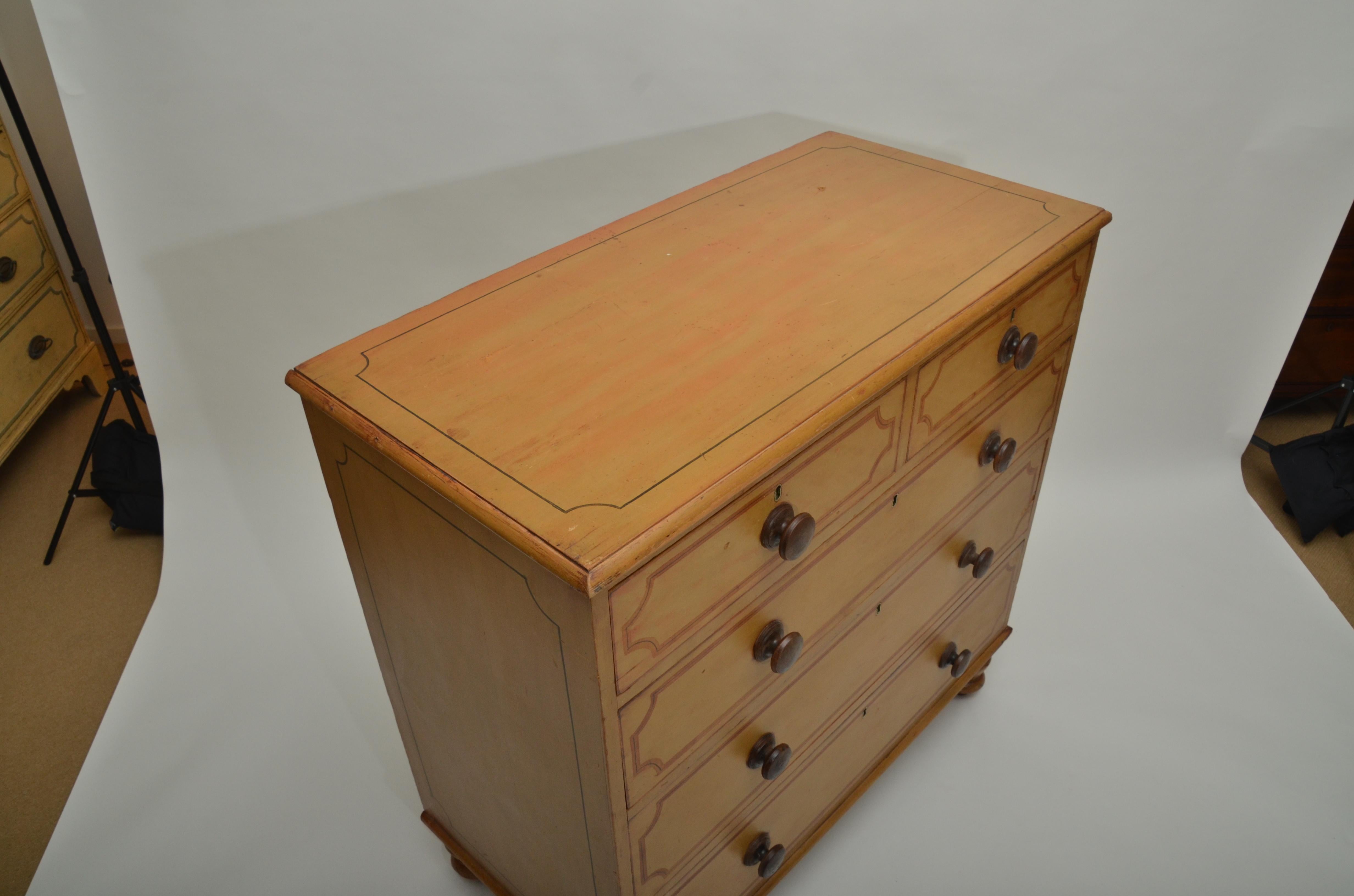 Painted pine with two short drawers over three long, original paint and knobs. Turned bun feet, mustard color.