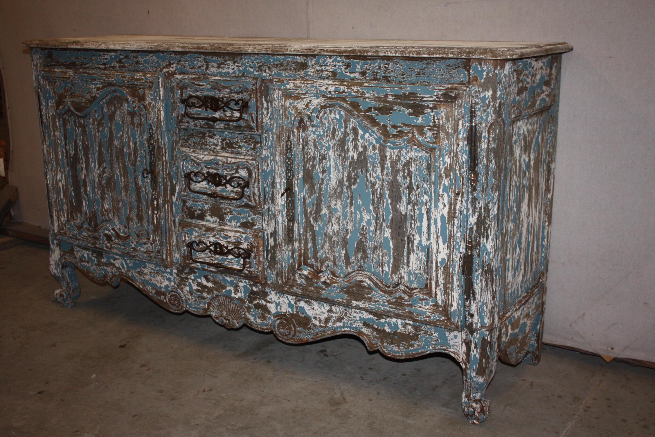 This is a very attractive painted French buffet that dates to the early 1800s. It is very nicely constructed of white oak. The hardware is very substantial, attractive. It has three drawers flanked on each side by doors.