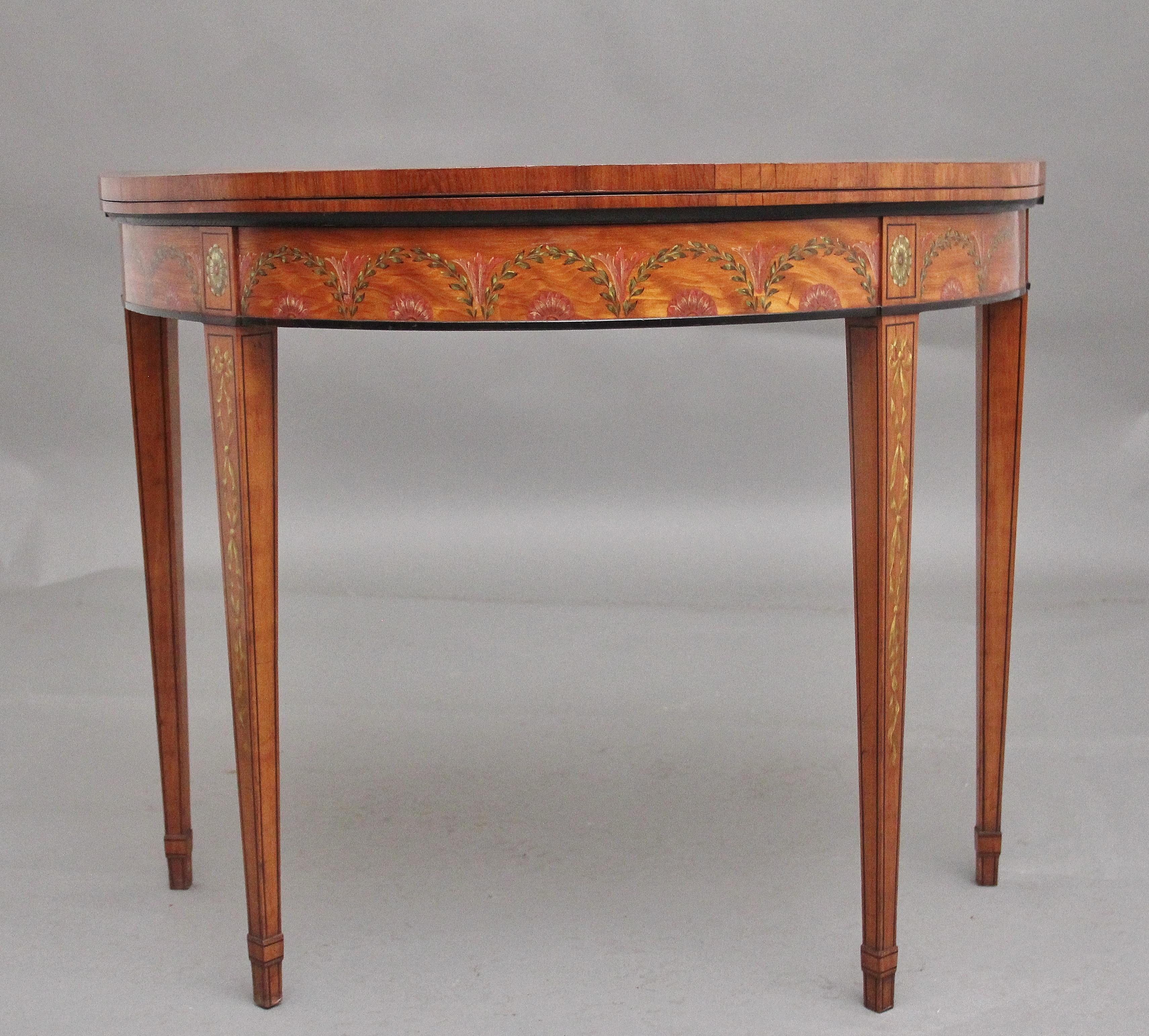 A highly decorative and fabulous quality early 19th Century painted satinwood card/games table in the Sheraton style, having a nice figured top with painted floral decoration, the top opening to reveal a baize playing surface, the frieze below with