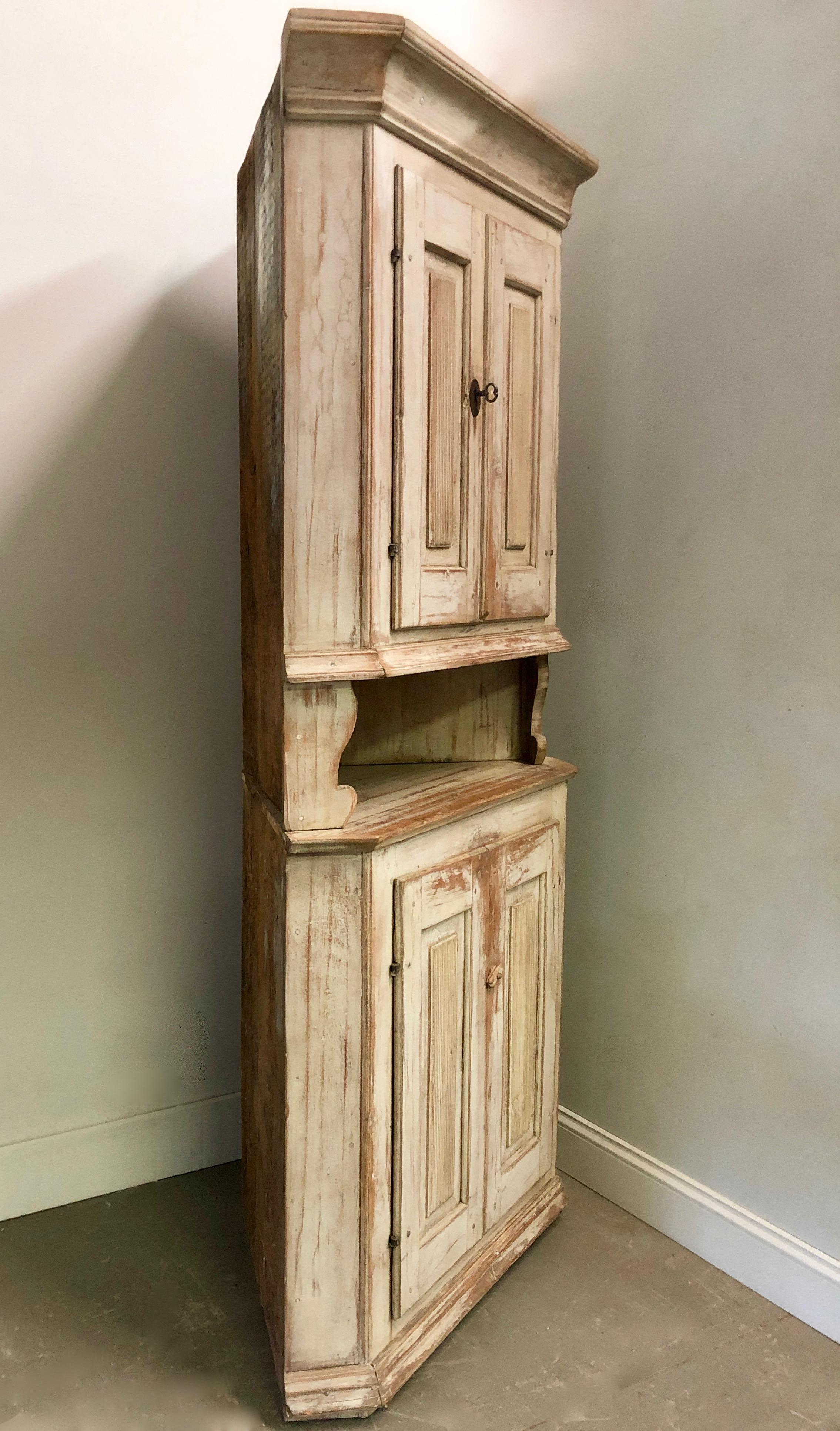 Charming early 19th century painted Swedish corner cabinet in two parts with reeded panelled doors and small cubby hole between the top and bottom in original time worn patina.
Sweden, circa 1800.
Surprising pieces and objects, authentic,
