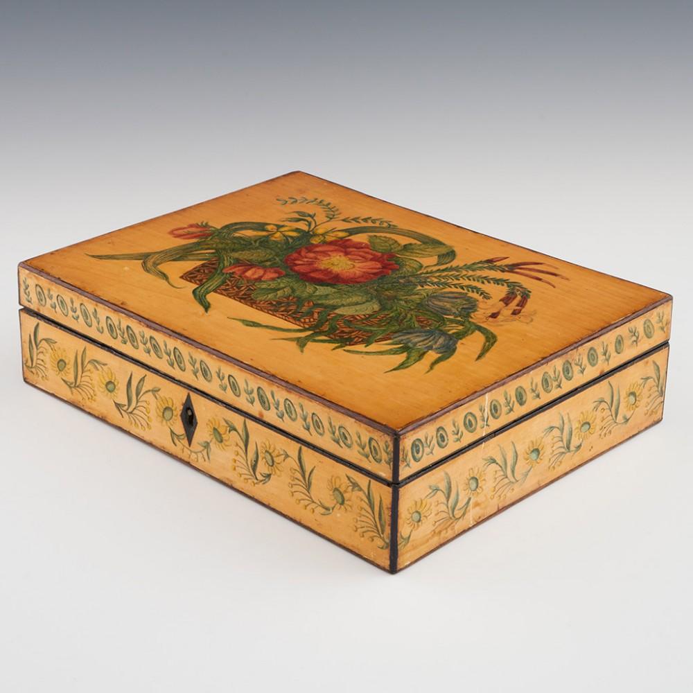 Heading : Painted whitewood box
Date : 1800-1830
Period : Regency
Origin : Probably Tonbridge or Tunbridge Wells, Kent
Decoration : Rectangular whitewood box with painted basket of flowers to cover and foliate banding to side panels. Original pink