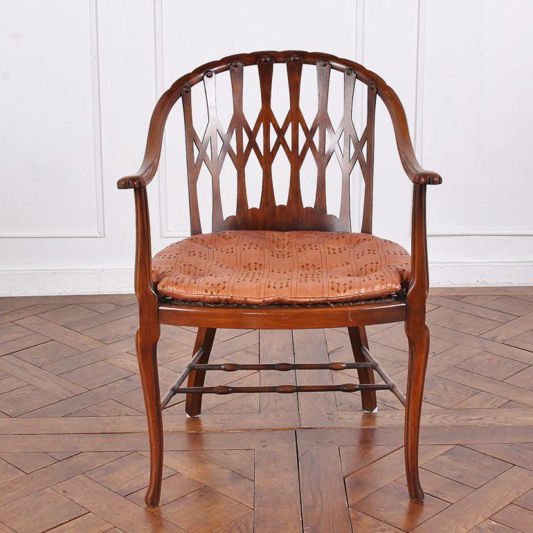 A pair of mahogany-frame small armchairs, with an unusual curved back profile and pierced lattice backrest. Cane seats in need of restoration.