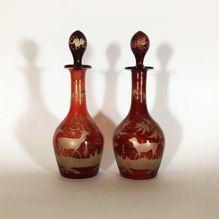 Splendid pair of blown red crystal bottles with golden engravings depicting hunting scenes, made with great skill and precision. Every detail, from the plants to the lawn, is rendered with great care and attention to detail. The decorations