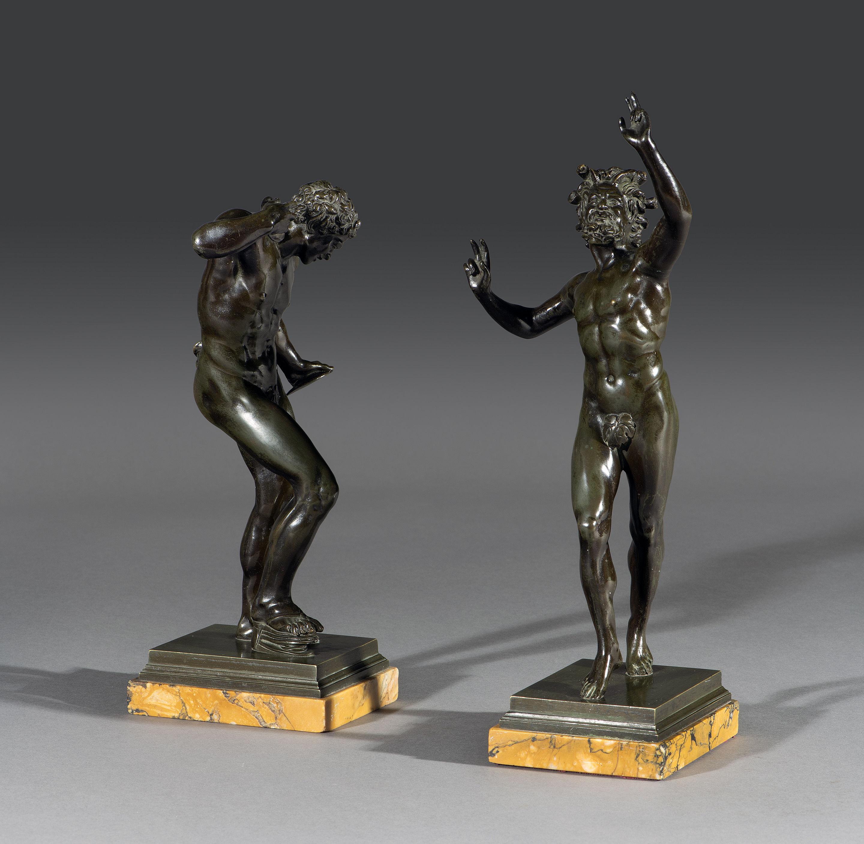 The pair of bronze 'Grand Tour' figures are after the original antique of ‘Dancing Faun with Clappers’. The darkly painted bronze statue of the iconic woodland faun from Greco-Roman mythology is depicted with pointed faun ears, tail and frenzied