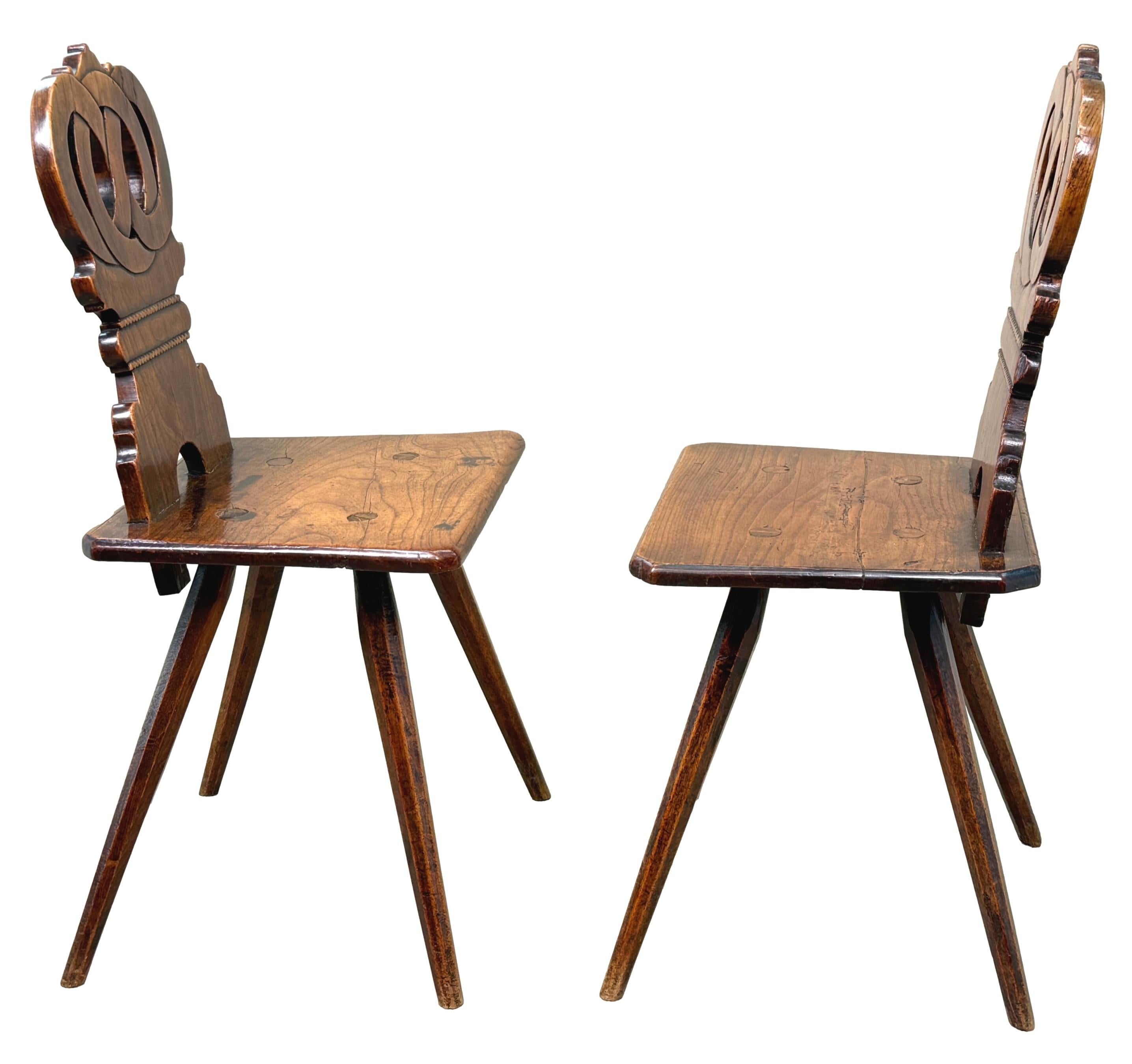 A Stunning And Extremely Charming Early 19th Century Pair Of Fruitwood Folk Art, Swiss Escabelle Chairs, Or Hall Chairs, Retaining Wonderfully Rich Colour And Patina Throughout, With Attractive Pierced & Interlaced Decoration To Backs, Over Highly