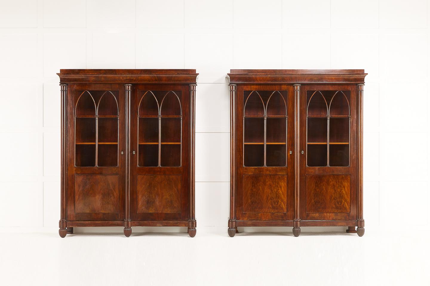 Pair of quality early 19th century French empire period bookcases in beautiful flamed mahogany. Doors with original old glass with nice fine carvings and two arched glazed bookcase doors.