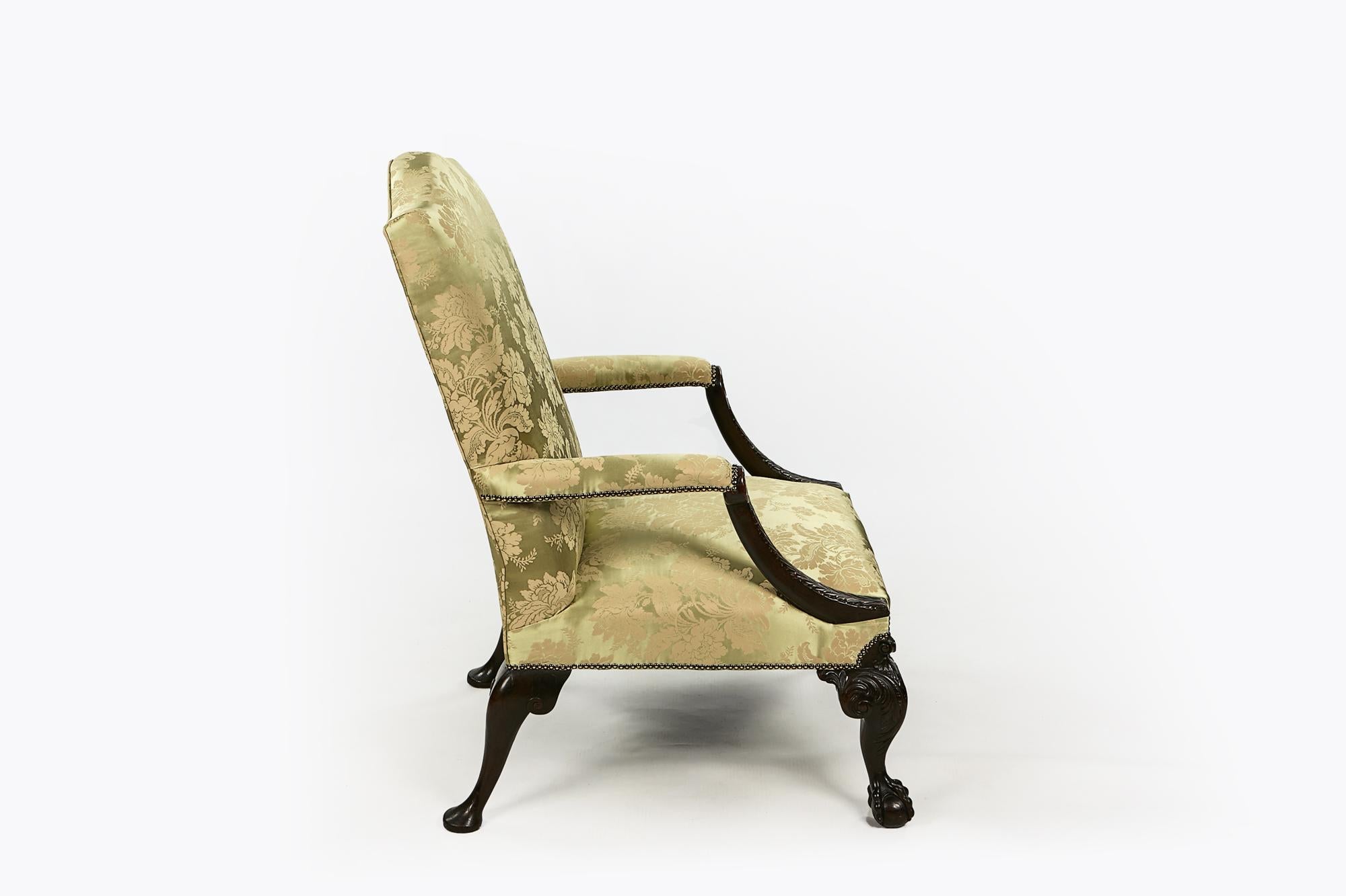 Paire de fauteuils Gainsborough en acajou, rembourrés, du début du 19e siècle. Le dossier carré, arqué et rembourré, surmontant des accoudoirs rembourrés avec des terminaisons sculptées de motifs d'acanthe, repose sur un pied cabriole avec des