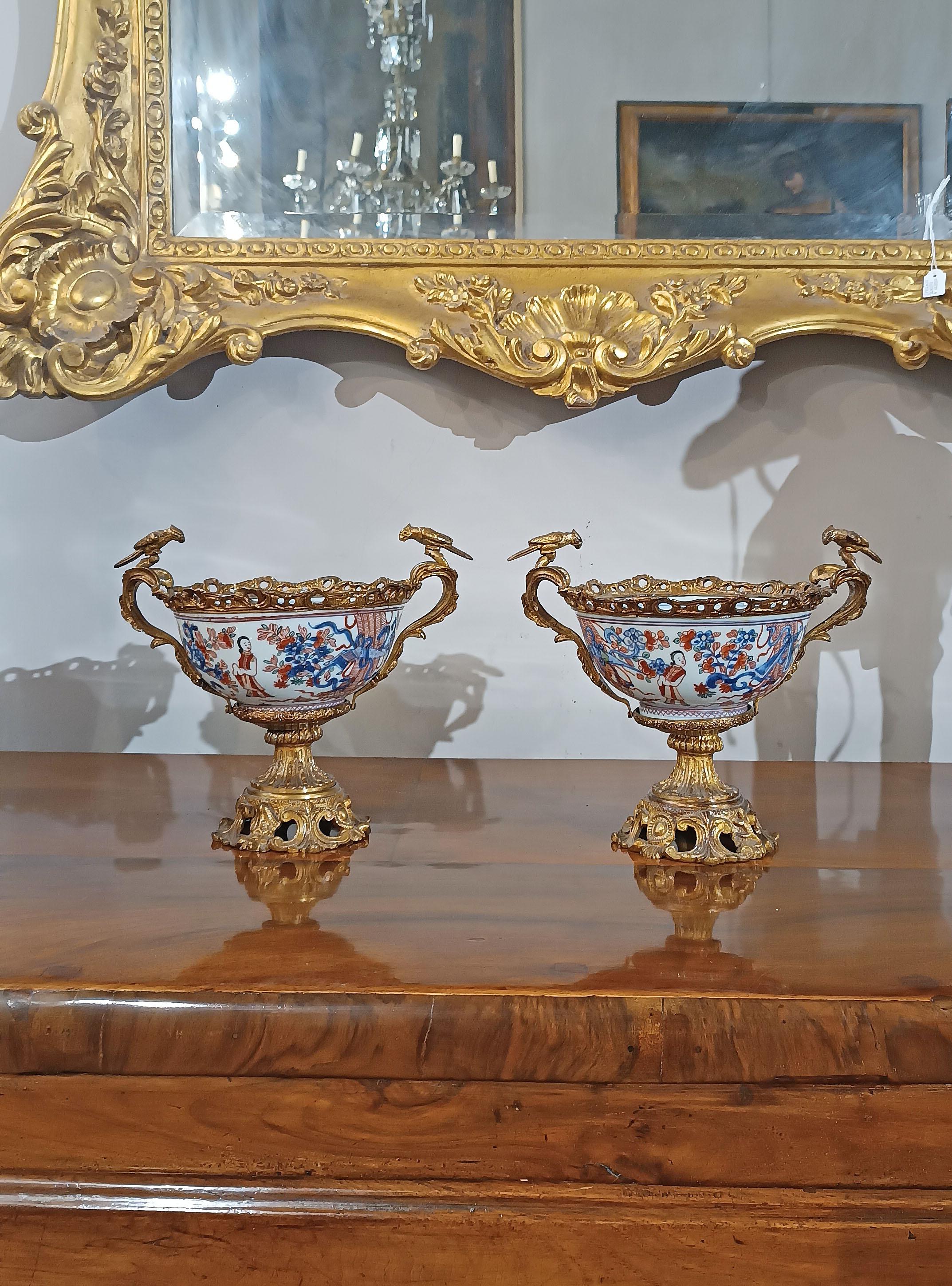 Hermoso par de tazas de porcelana Imari con fundición a la cera perdida francesa y monturas de bronce dorado. Las monturas de bronce, ricas y elegantes, representan brotes de plantas con asas rematadas por pequeños pájaros, que aportan clase y