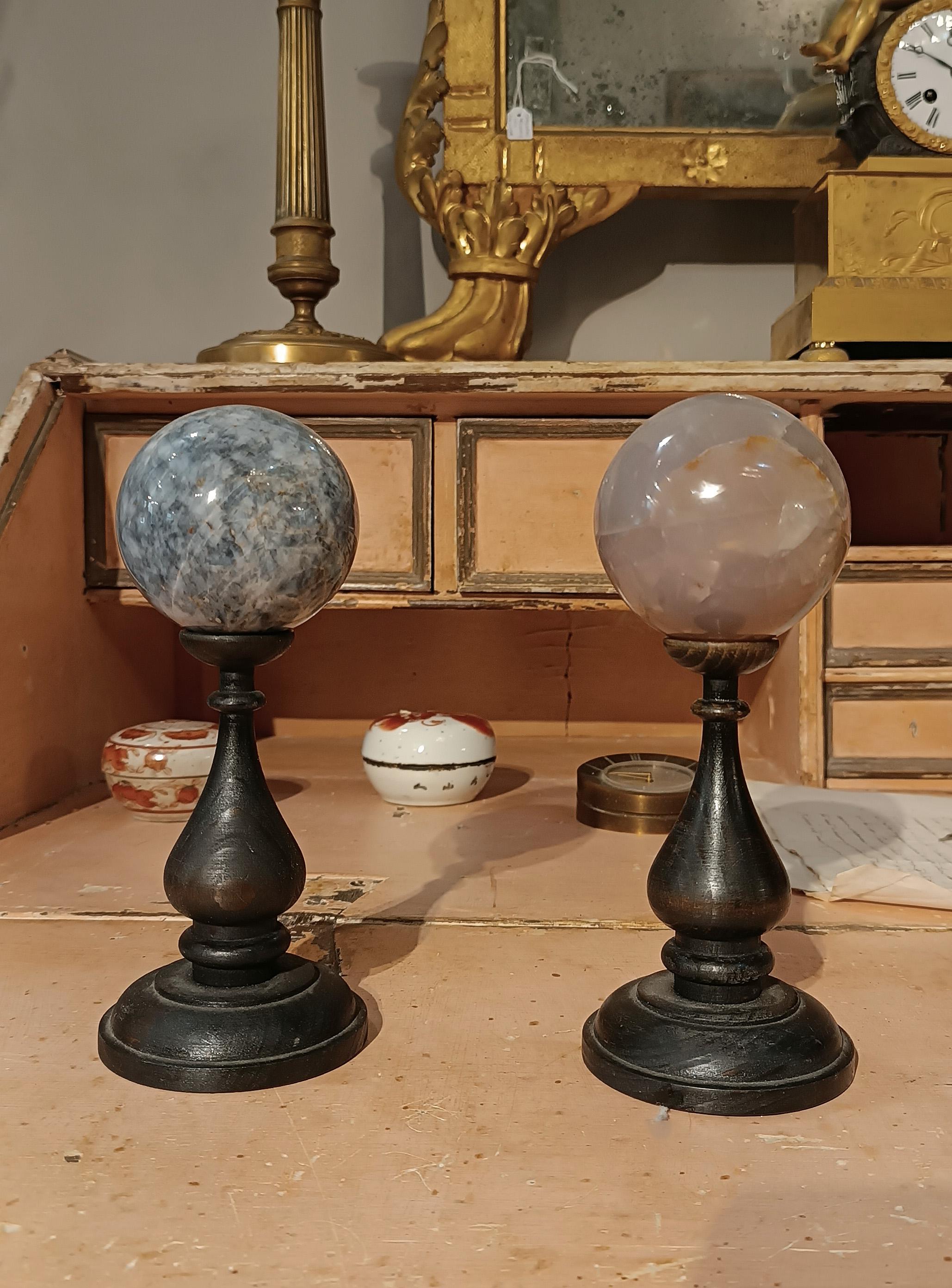 Delightful pair of quartz spheres, embellished with turned and ebonized wooden risers. The quartz spheres are in perfect condition, crystal clear and without imperfections. These small objects can add a touch of class and sophistication to any