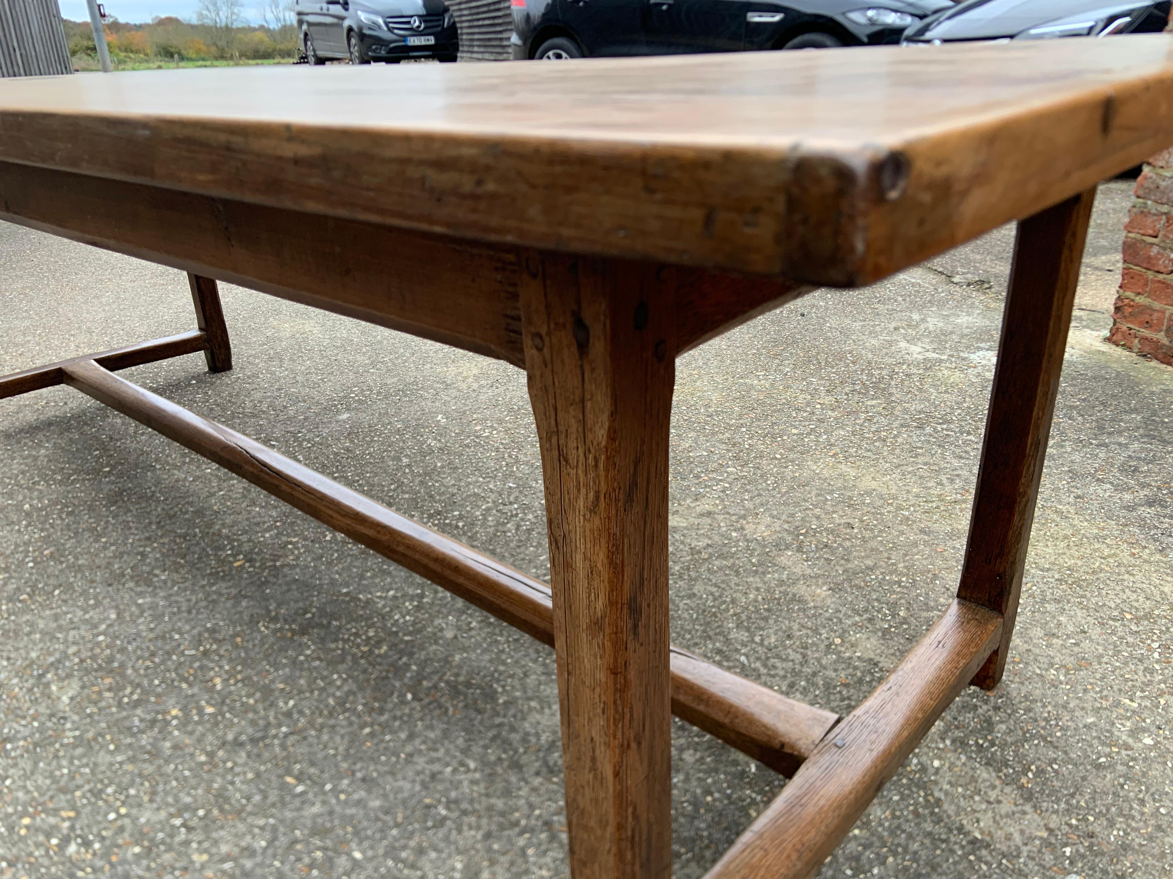Antique pale cherry and oak farmhouse table with centre stretcher. Beautiful figured three plank top with oak centre stretcher.
   