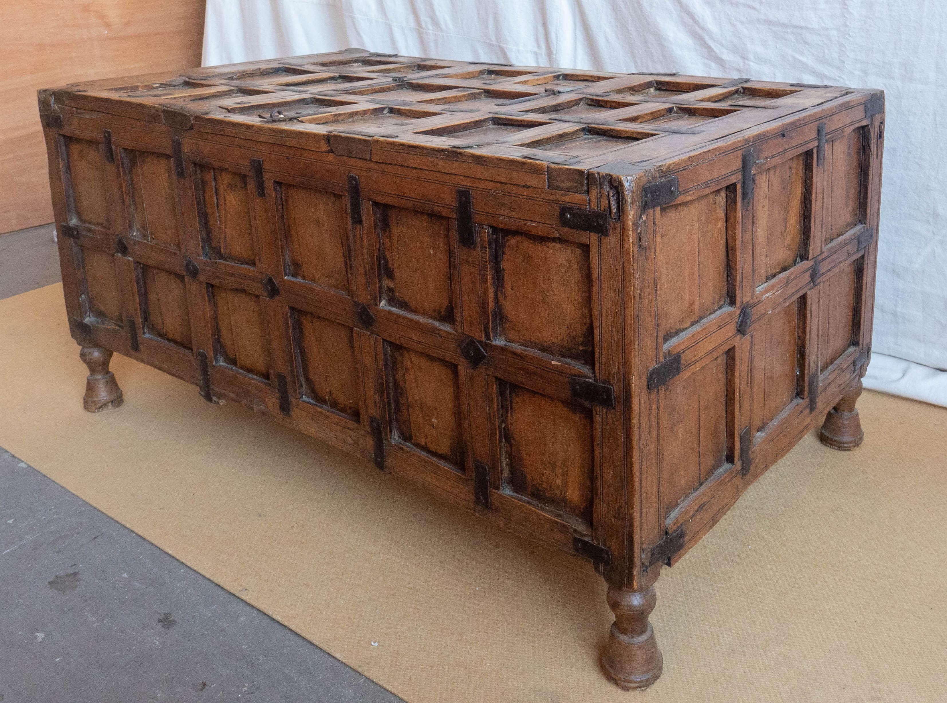 Early 19th century coffer or trunk. Crafted from fruitwood with panels and iron banding strips/accents throughout. Top with hinged flap for interior access. On turned and incised bell form feet.