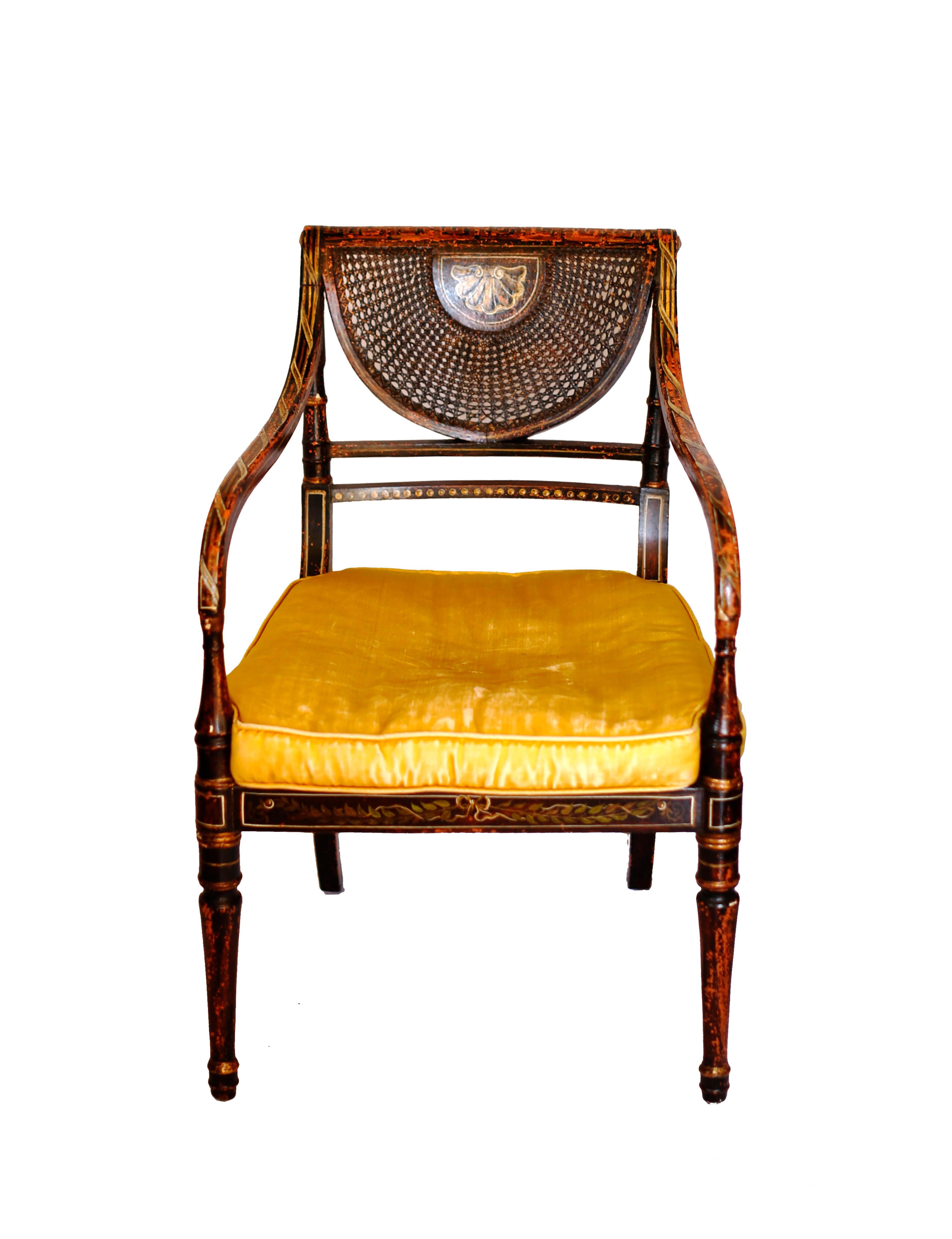 A beautiful period Hepplewhite style armchair with painted finishes and gilt detail. The painted surface reflects the influence of Swiss neoclassical painter Angelica Kauffman (1741-1807) with ribbons, garland, and Greek key motifs. The caned back