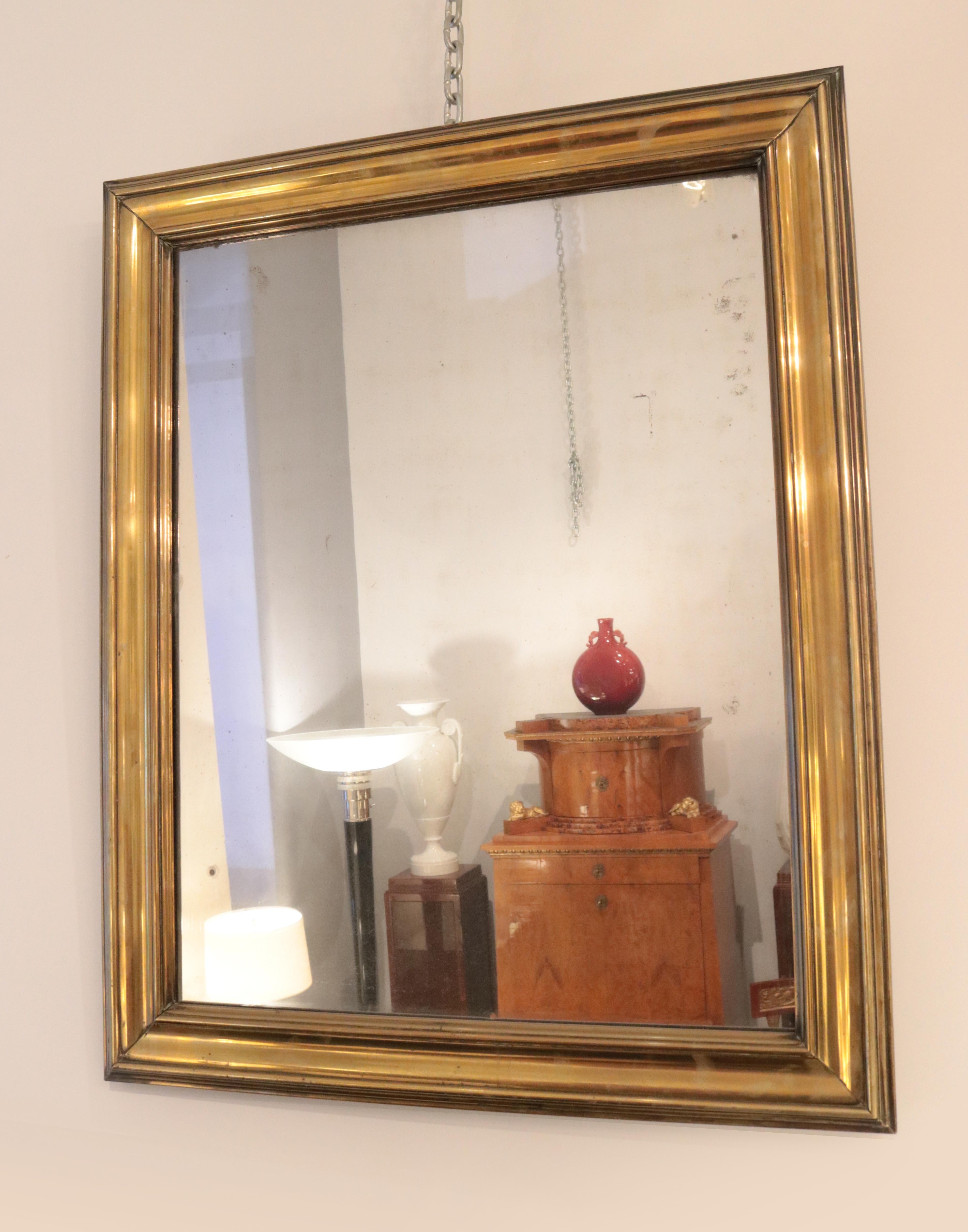 An early 19th century patinated brass mirror.
Patinated brass profiles over a wooden frame.
