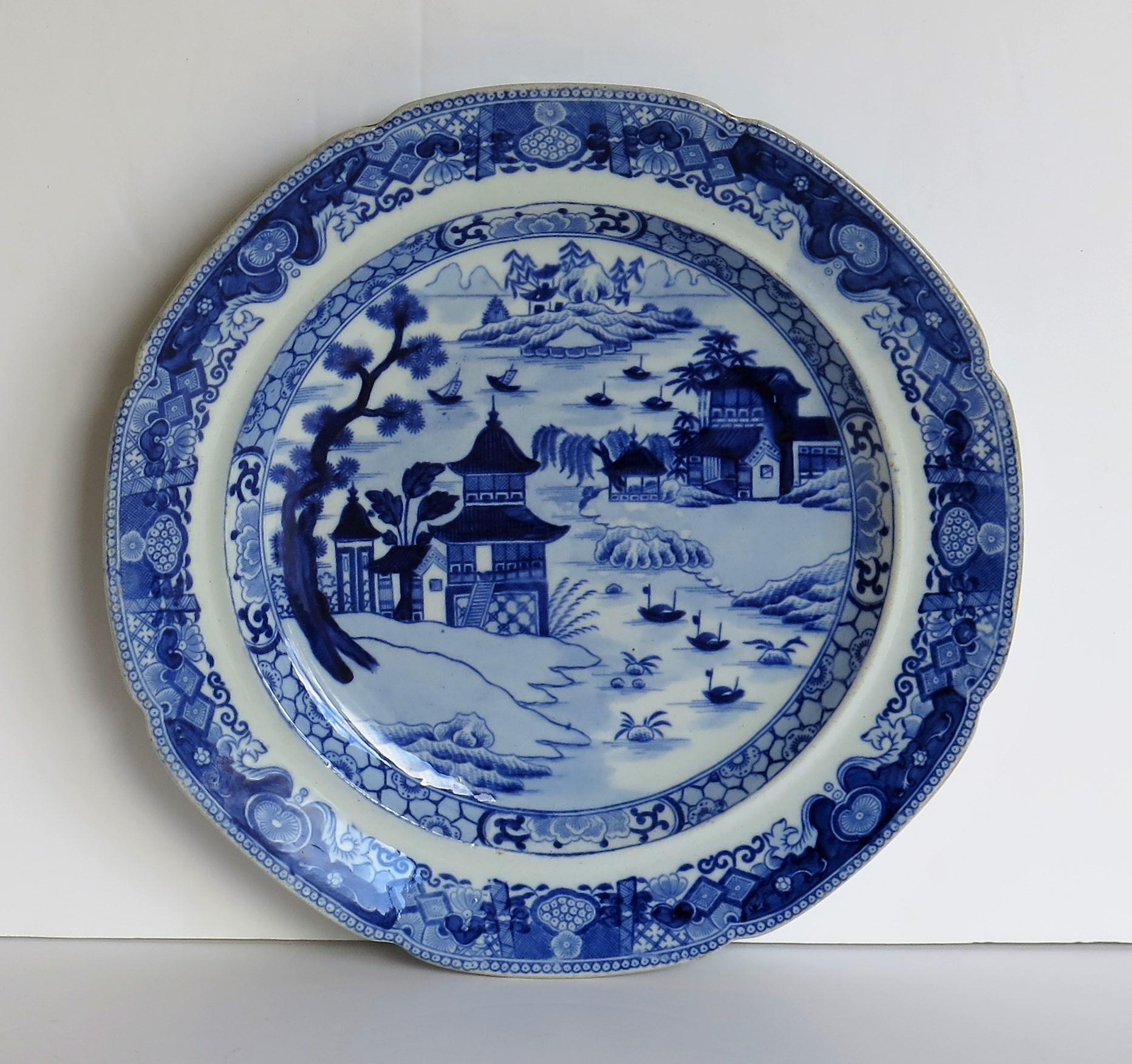 This is a beautiful early plate in a printed blue and white chinoiserie pattern and made of a type of earthenware pottery called pearlware, in the very early 19th century, by one of the English Staffordshire Potteries, circa 1810.

This is a large