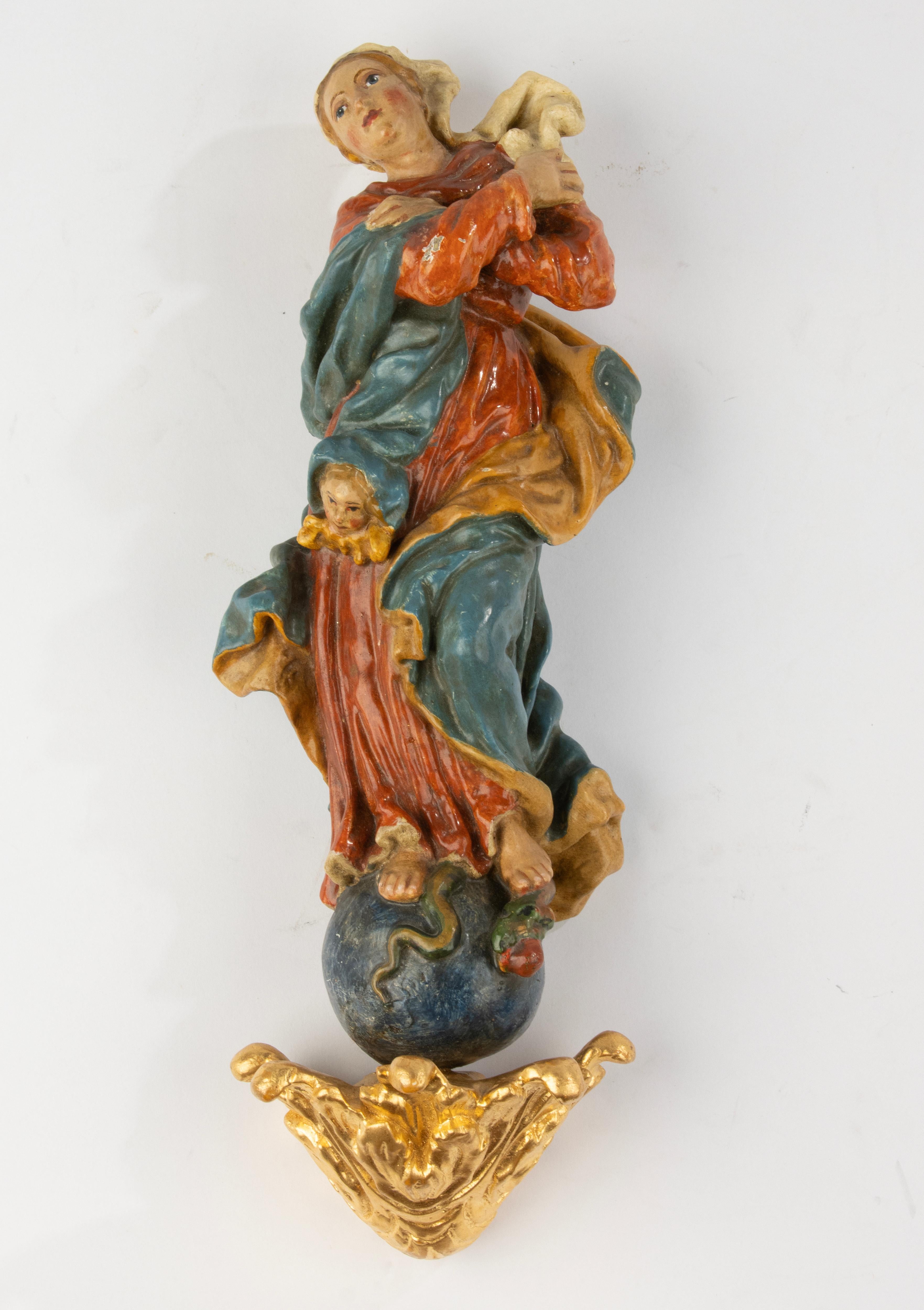 This finely carved and polychrome-painted wooden sculpture depicts the Immaculate Virgin Mary in a classic pose, standing atop the globe with a serpent beneath her feet — a powerful symbol of purity and divine protection. Likely crafted in Southern