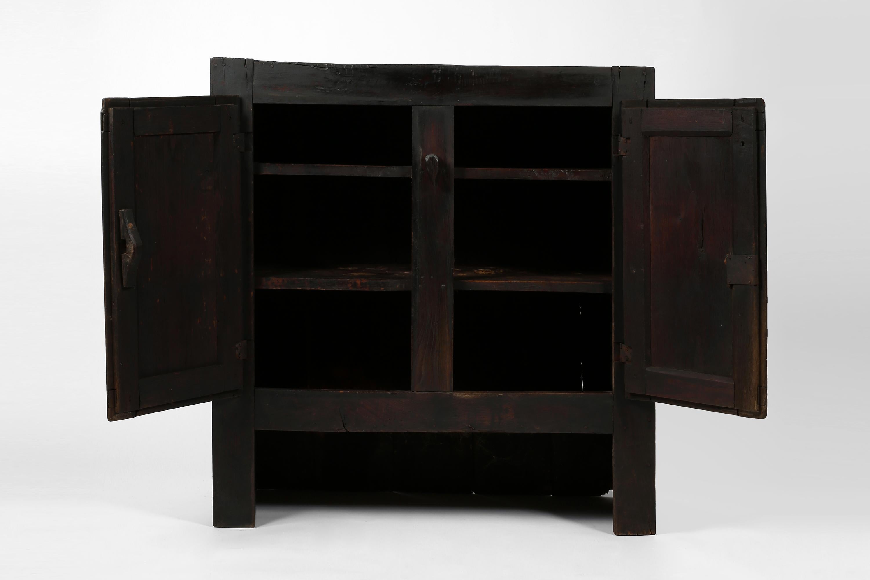 Armario de granja de principios del siglo XIX construido con madera de castaño muy patinada, casi ennegrecida. El armario, que probablemente formó parte de un mueble más grande, es de construcción ingenua, aunque tiene dos puertas decorativas con