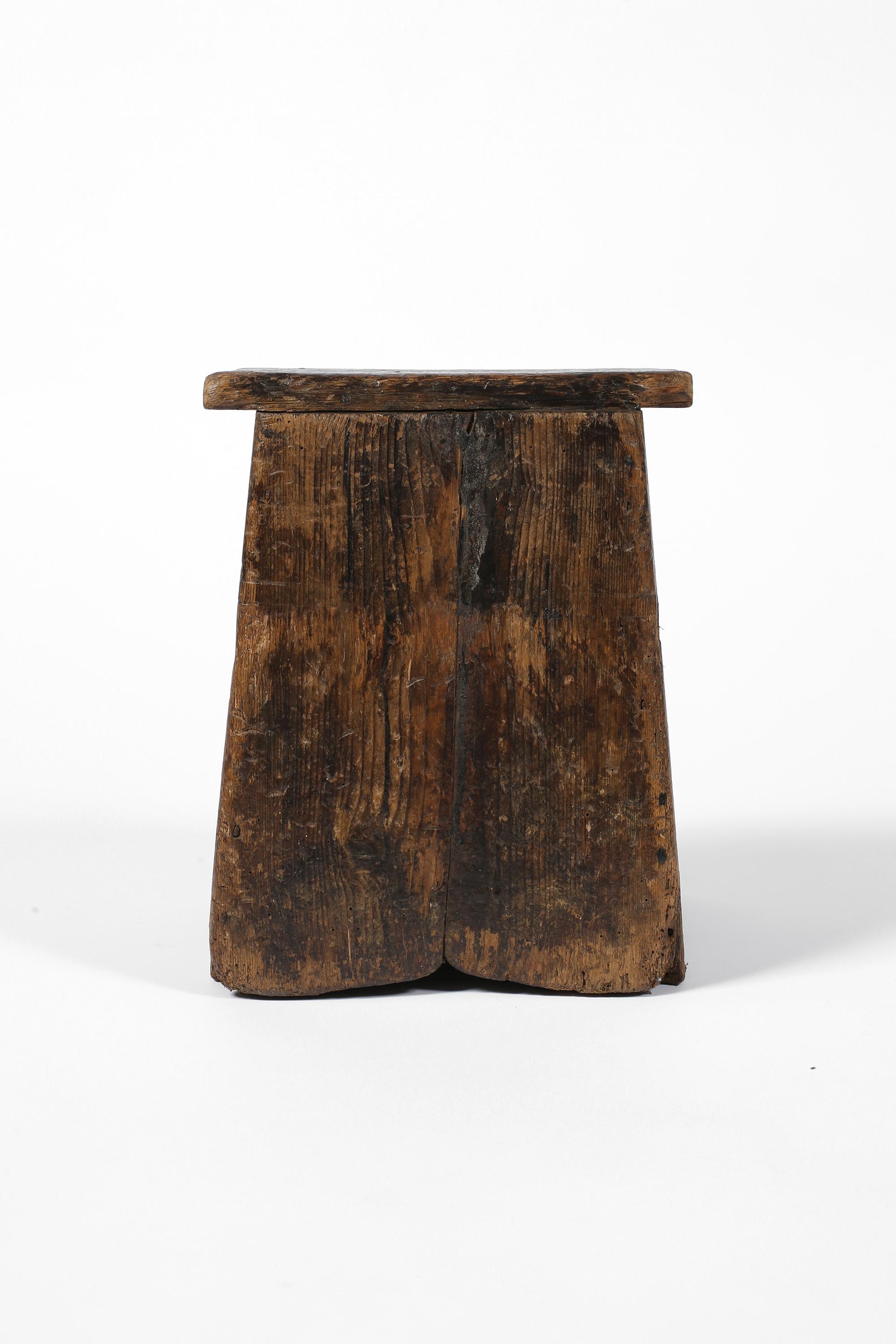 Pequeño y encantador taburete vernáculo de madera de pino patinada en profundidad, de construcción sencilla y entablada, con orificio de carga moldeado en el asiento. Escocés, c. 1800.