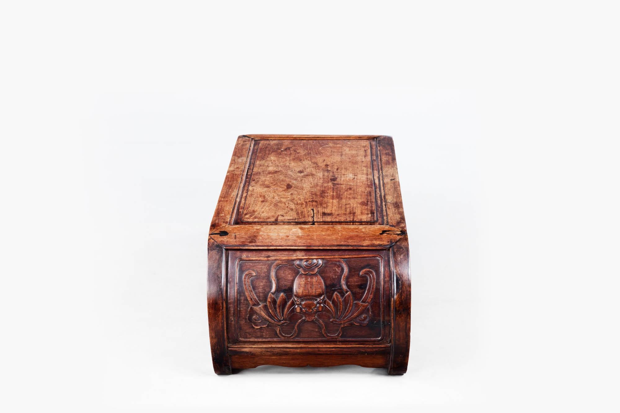 Early 19th century Qing Dynasty period Chinese hardwood low Kang table. The curved body terminates in scrolled feet and the sides are carved with naturalistic symbols of animals and flora. A beveled rectangular central board sits above open fretwork