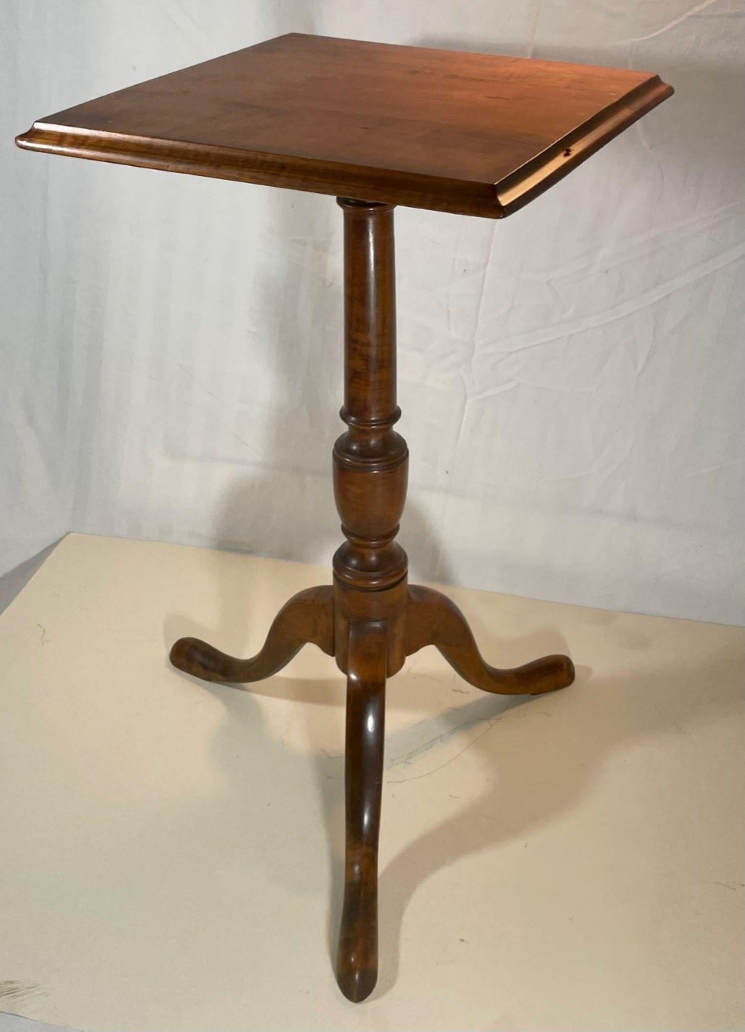 Early 19th Century Queen Anne New England tiger maple candlestand.

Antique 19th century Queen Anne square tiger maple candlestand. The ogee edged square tray top is raised on a well-proportioned turned pedestal, ending in tripod legs with snake