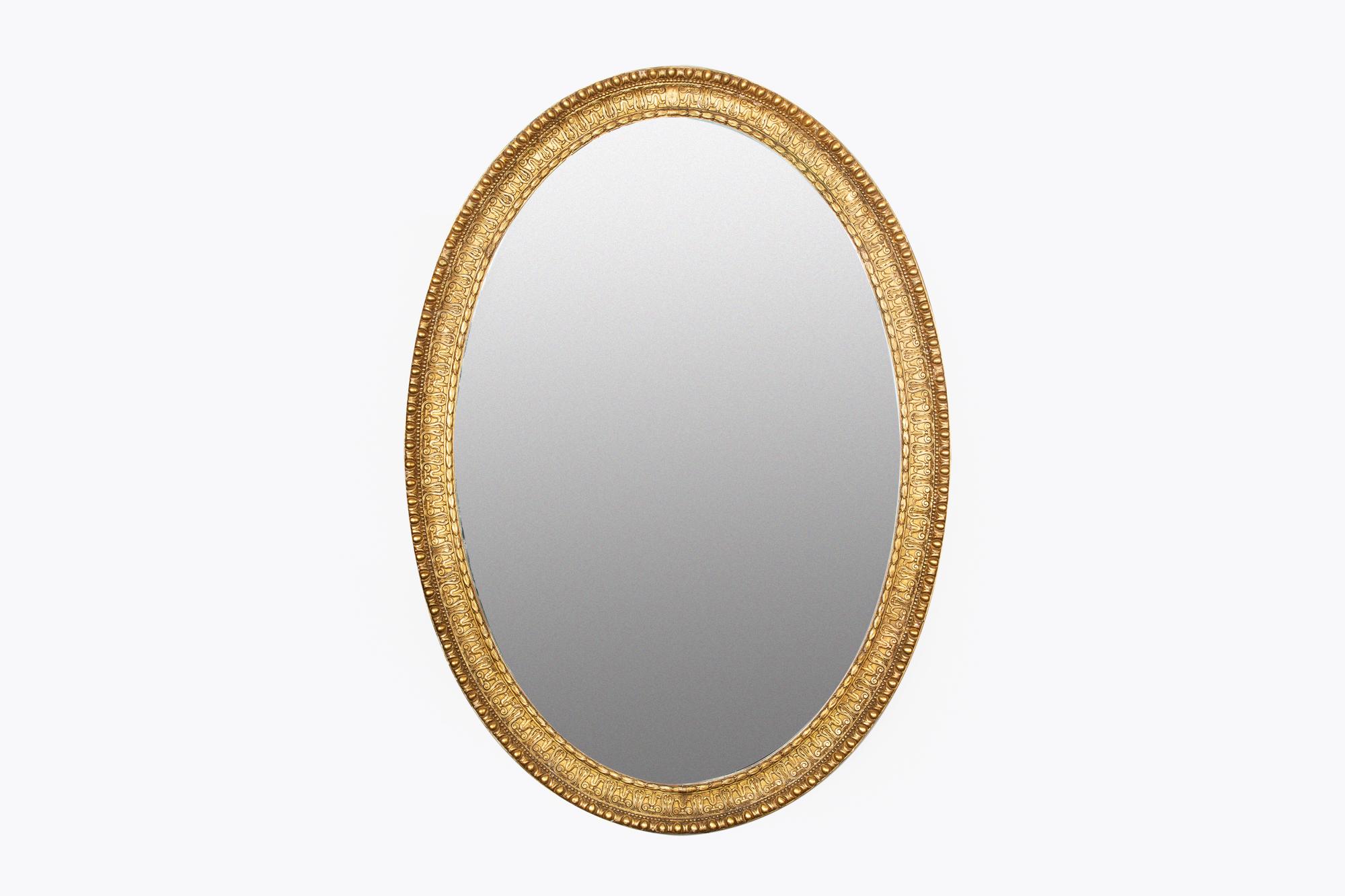 Early 19th century Regency rare pair of large mirrors. The mirrored plate of oval form set within carved giltwood frame of bands of wheatsheaf, lyre, beading and egg and dart motif, circa 1810.