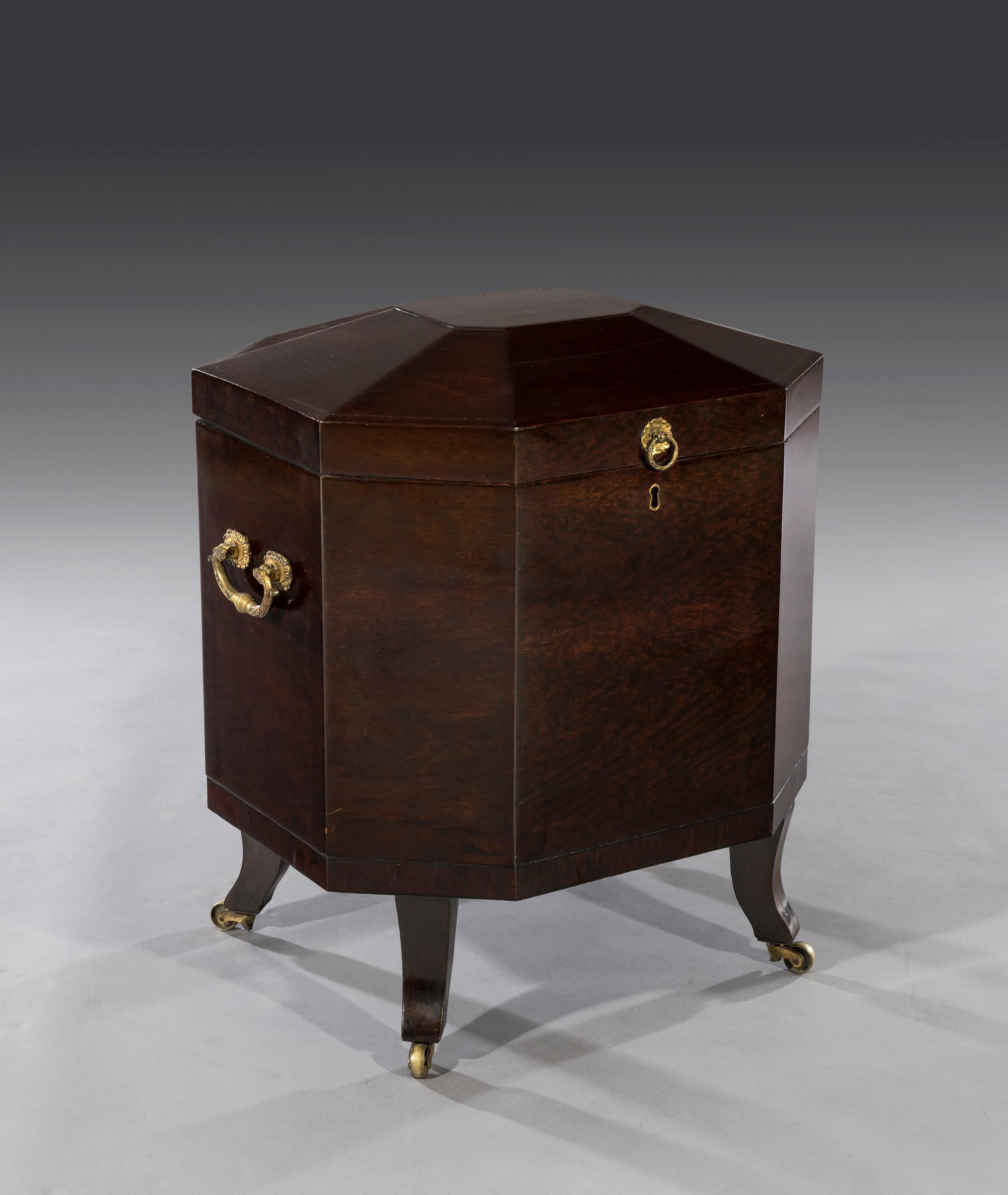 The octagonal shaped cellaret is veneered in partridgewood and is fitted with superbly cast brass carry handles and a ring-pull lid handle. The cellaret opens to reveal a later replaced metal liner that is removable and practical for storing,