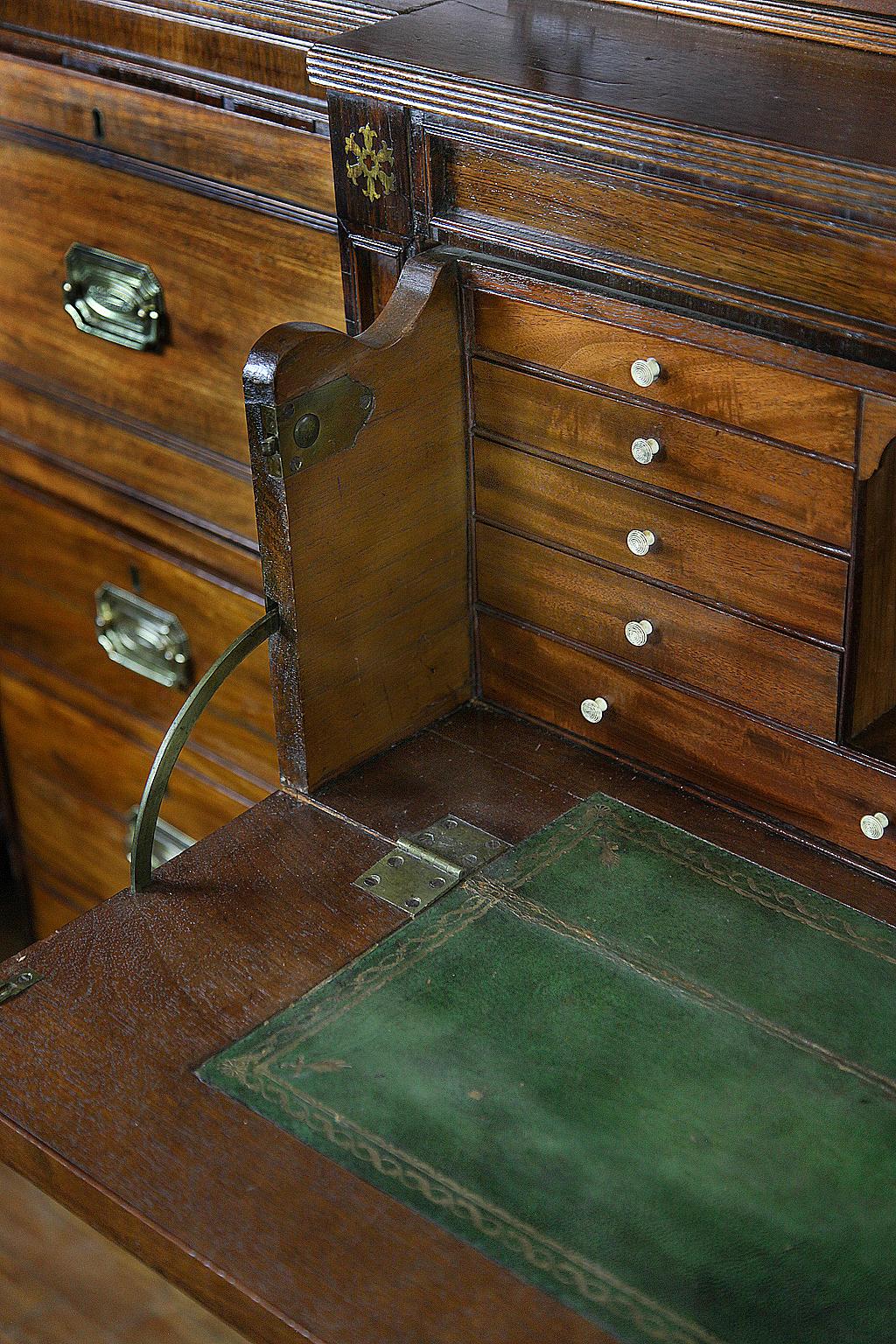 Early 19th century Regency breakfront bookcase, the pediment with inlaid brass medallions and central cartouche with inlaid brass ornament (these features repeat in the lower section), the glass doors with individual panes, the outer cases with