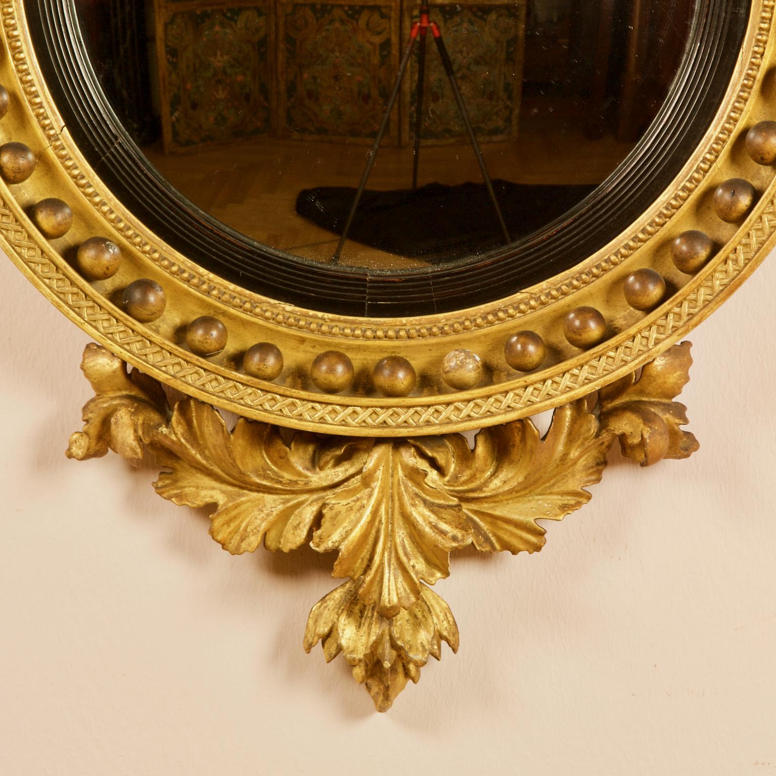 Early 19th Century English Regency Eagle Round Gilt and Ebonized Wood Convex Wall Mirror

A large early 19th century English Regency Neoclassical convex mirror in a round gilt and partially ebonized wood frame. The frame features gilt balls, a pearl