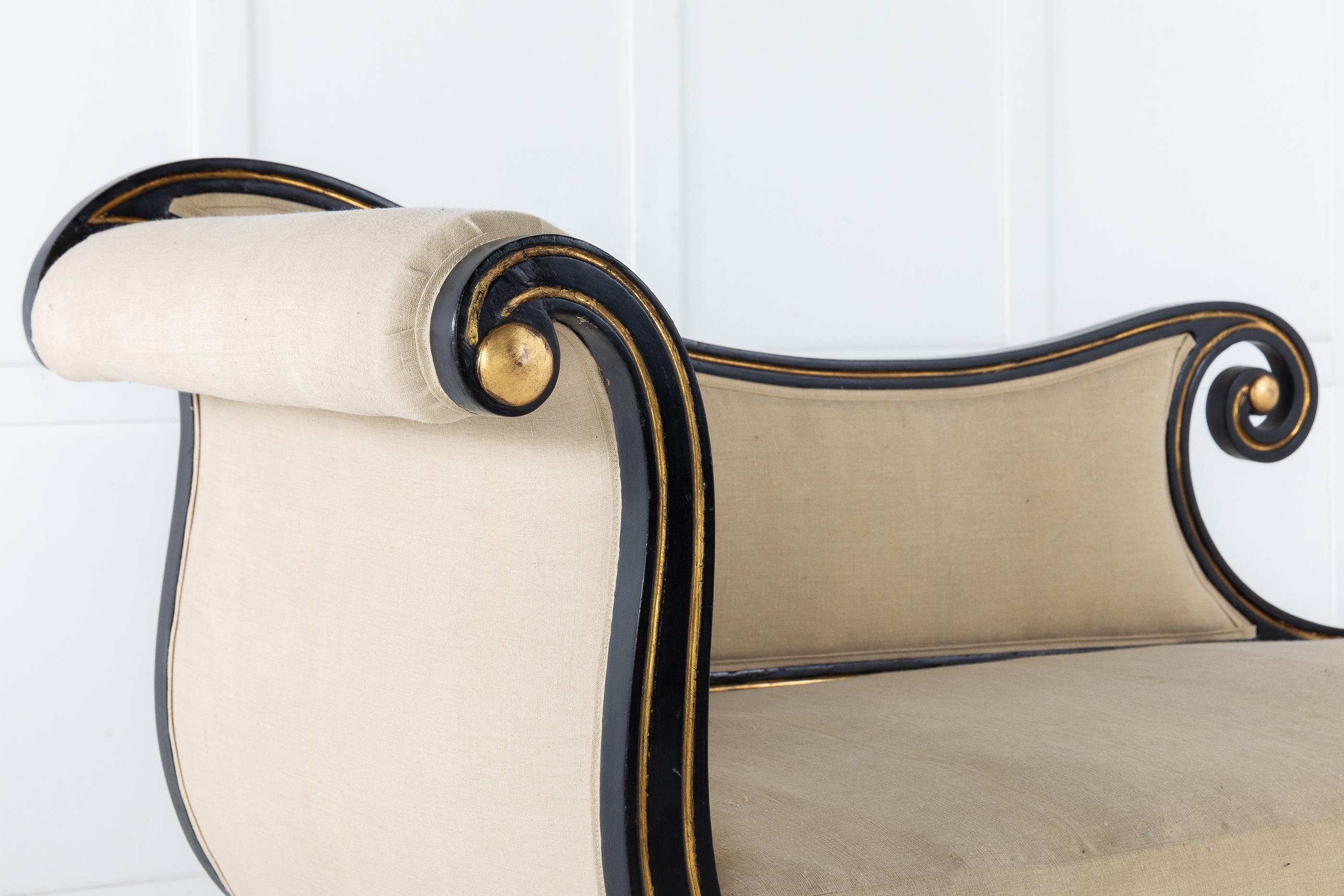 An attractive, elegantly shaped, early 19th century Regency period ebonized chaise lounge. Having an elegant overall shape decorated with gilt lines resting on well shaped sabre supports and brass casters.
