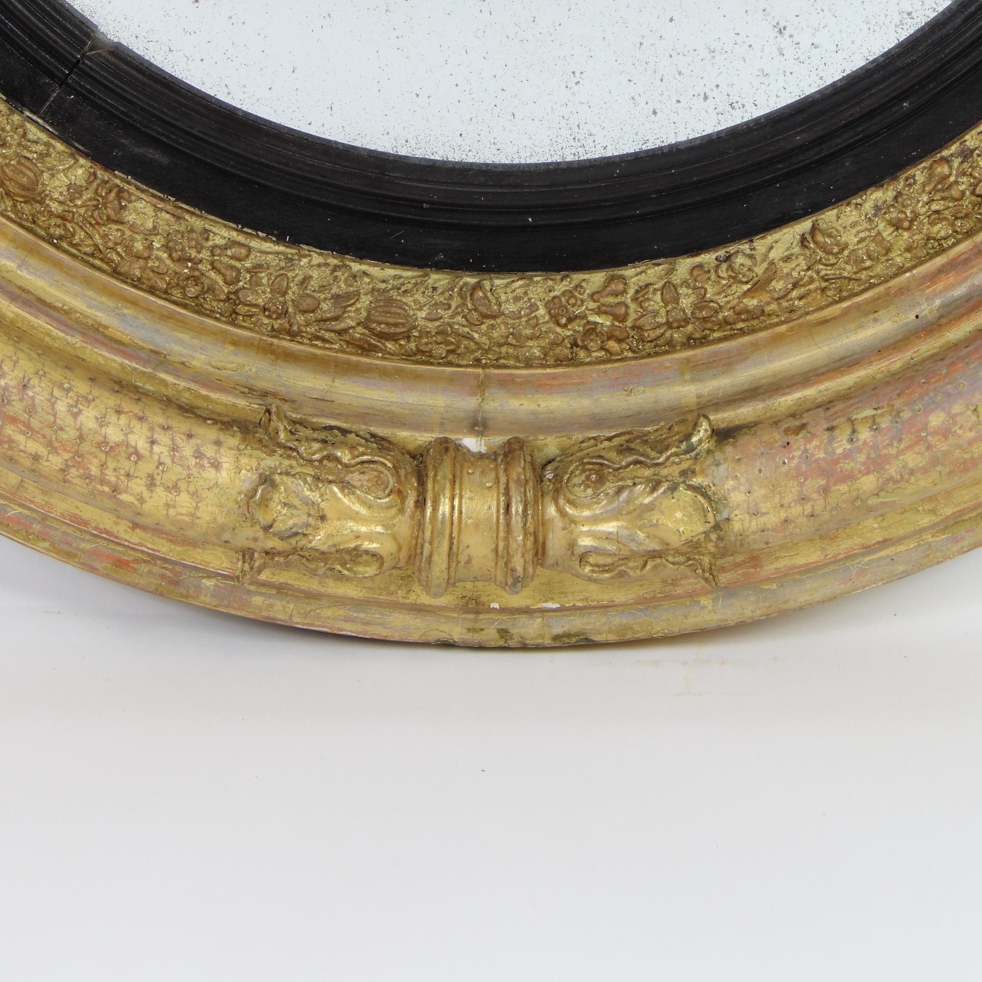 Early 19th Century Regency/Georgian Giltwood Circular Convex Butler's Mirror

Circular molded frame made of gilt and partially ebonized wood, decorated with rope-like elements with acanthus-leaf-joints, and  fine floral banding. Original convex