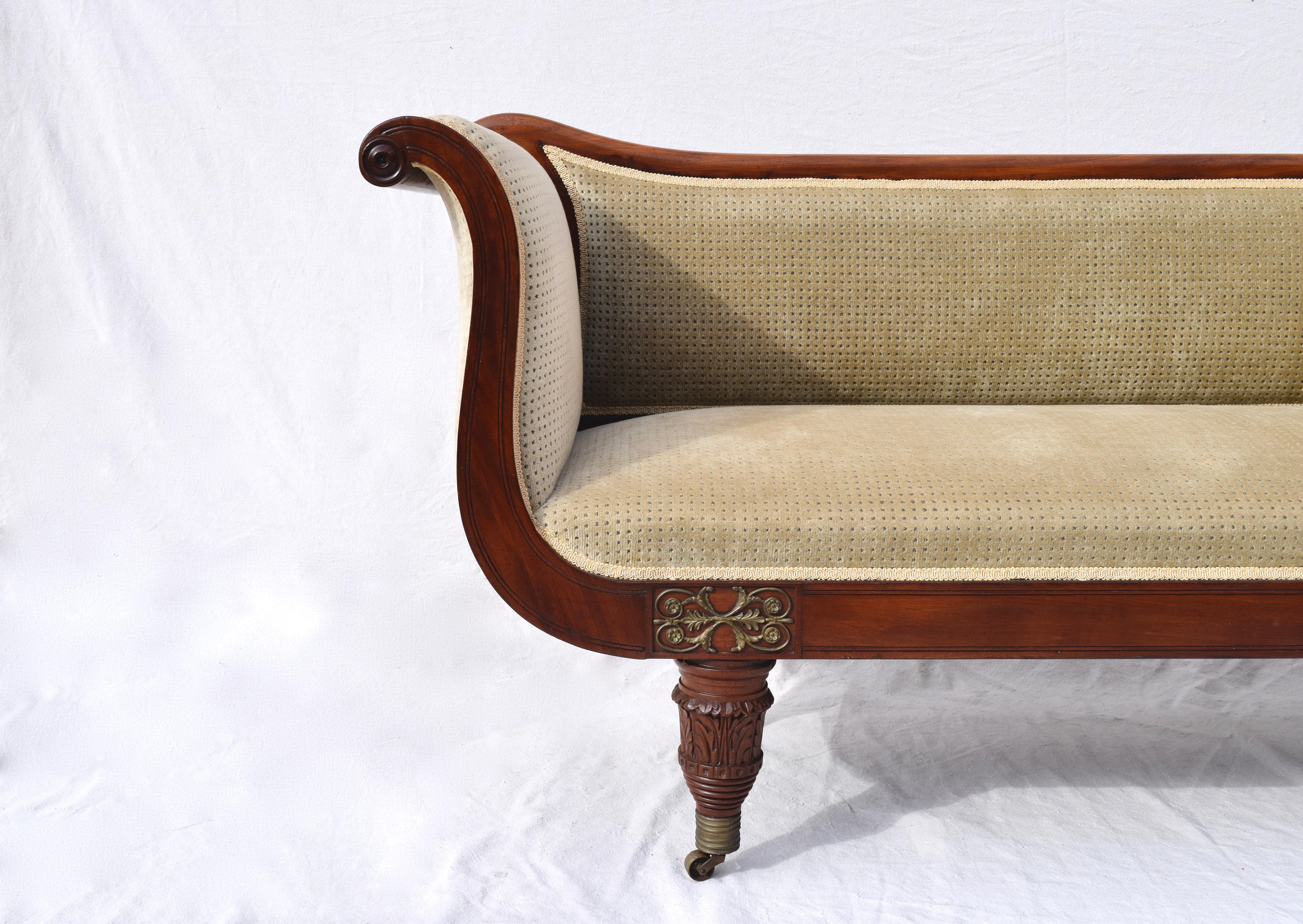 Elegant early 19th century Regency mahogany sofa or settee with scroll ends standing on turned legs and brass casters.
Classical in decorative and architectural influences of the 18th century this period of Regency furniture owes much to the