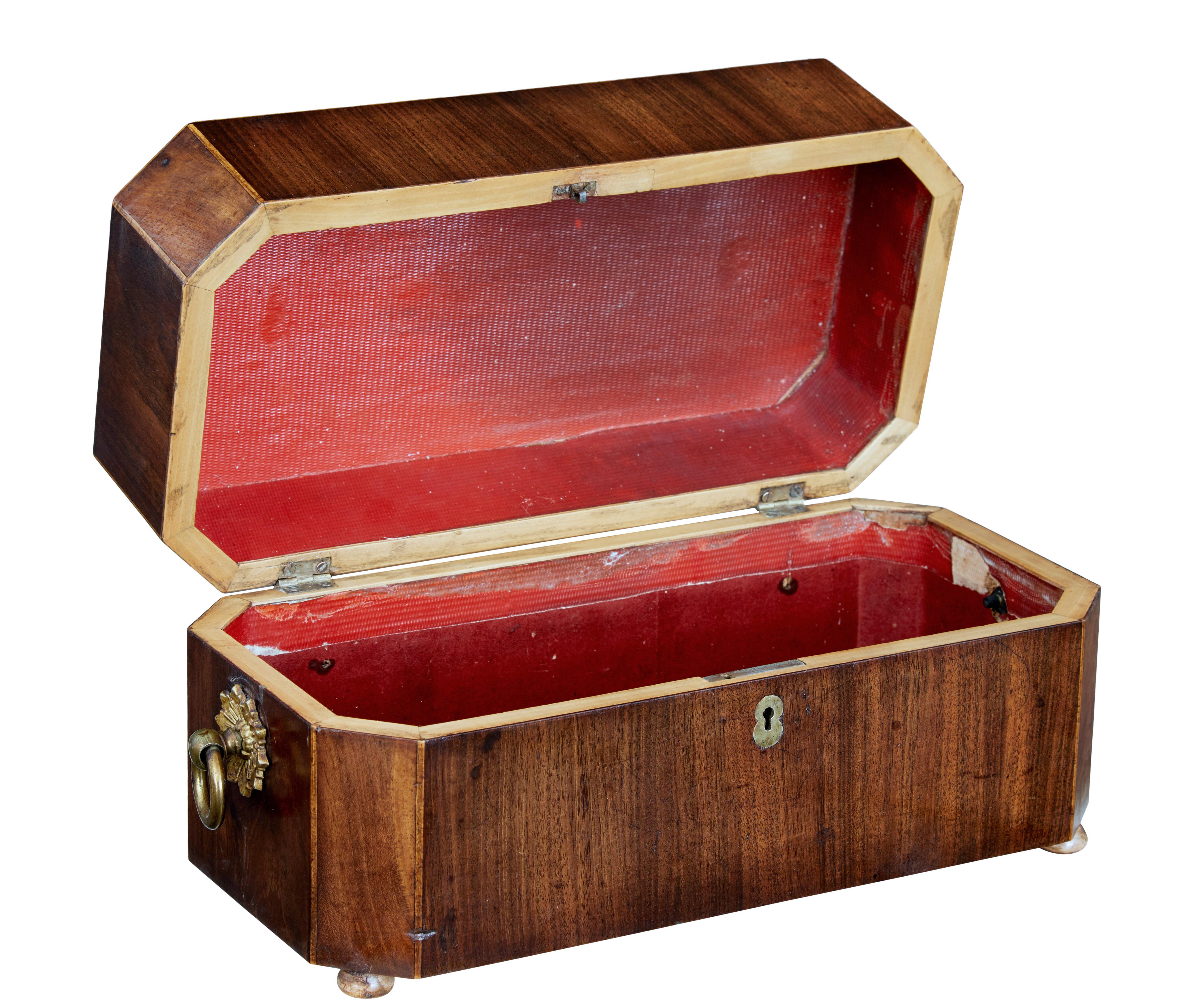 Good quality regency tea caddy, circa 1820.

Made using flame mahogany veneers. Brass handles with star motif to the sides. Canted corners strung with satinwood. Standing on flat bun feet.

Paper lined interior with no compartments or bowls.