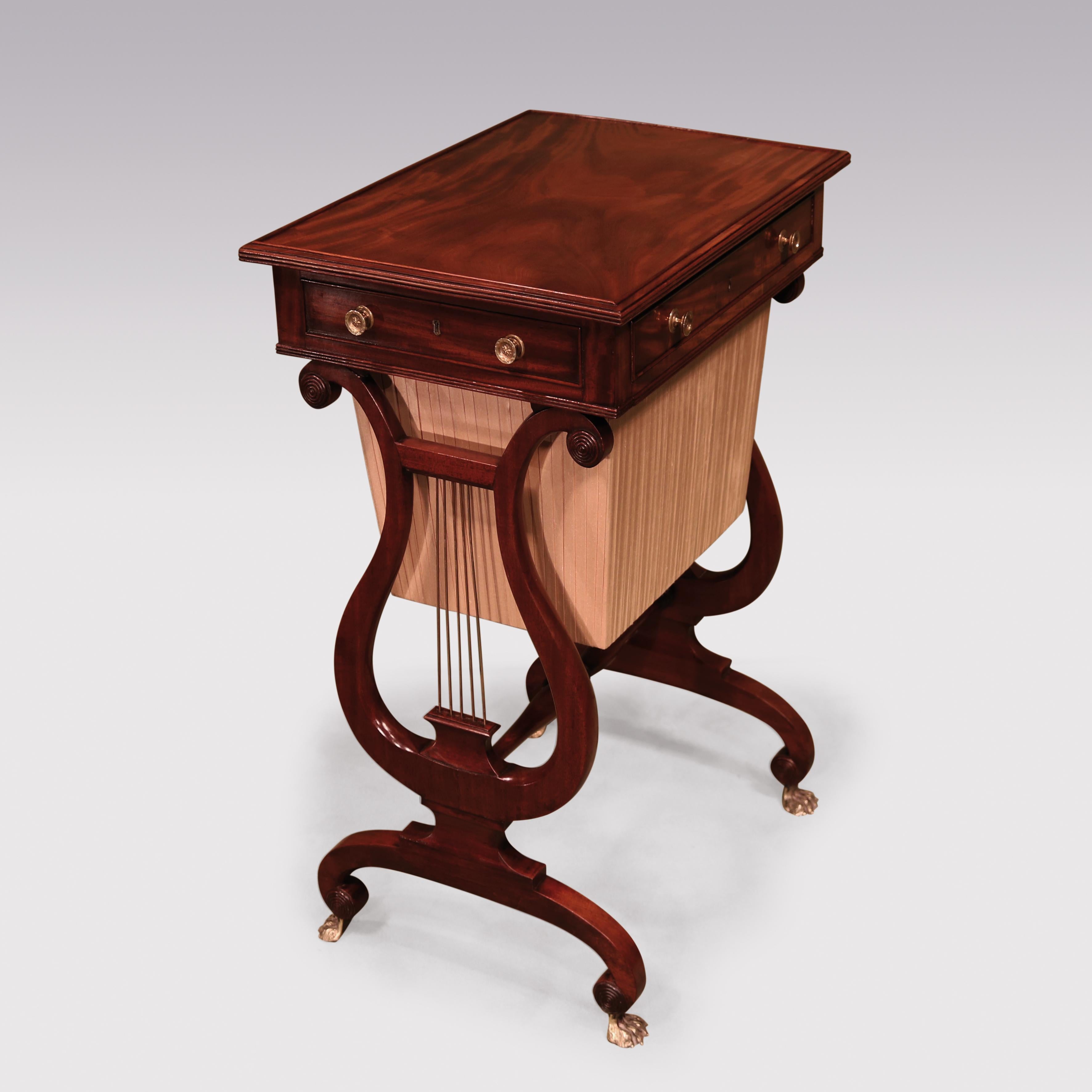 An early 19th century Regency period figured mahogany work table, having rectangular reeded edged top above 1 opening and 3 dummy cockbeaded drawers, raised on lyre end supports with central turned stretcher ending on umbrella shaped scroll legs