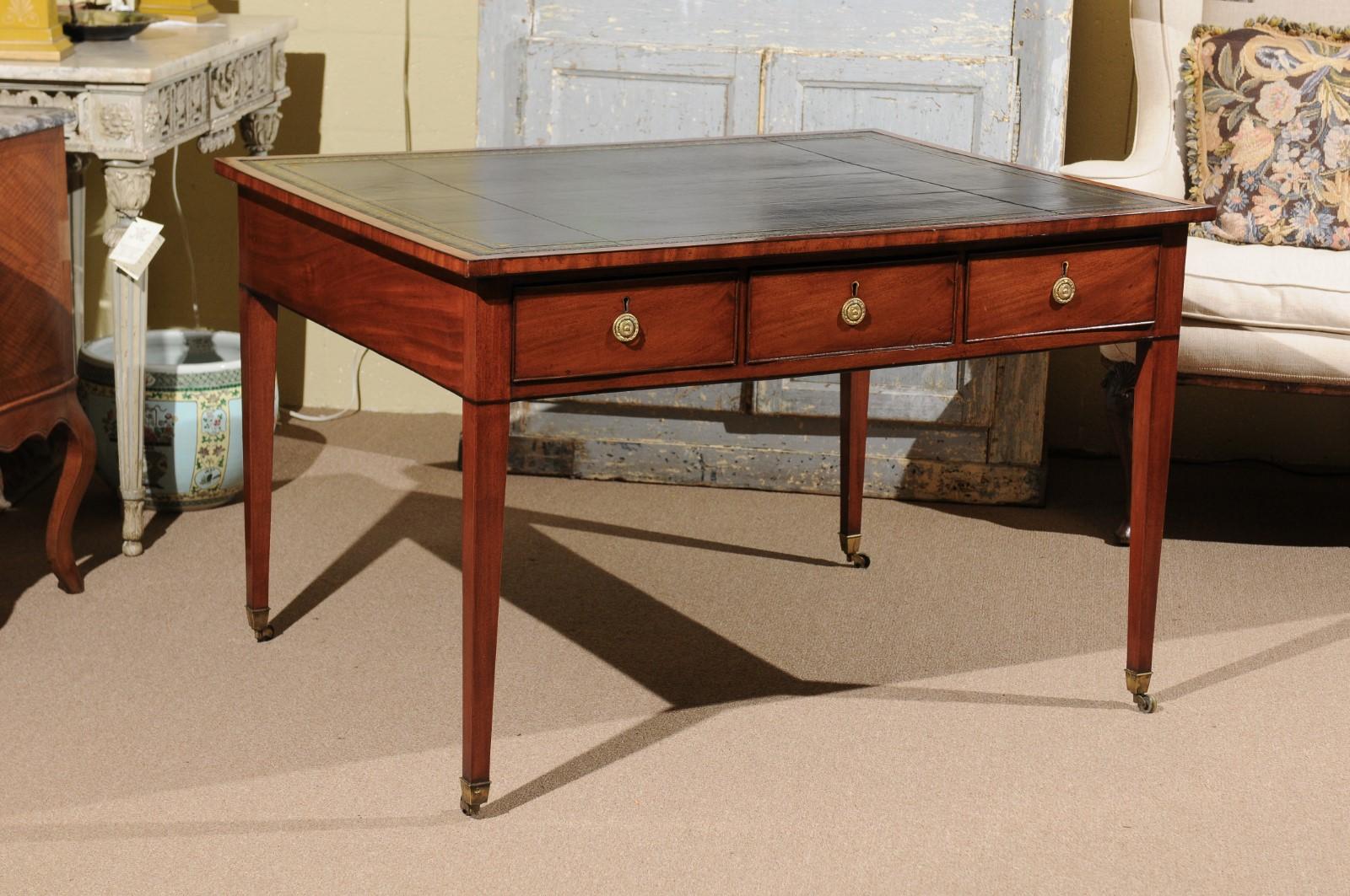 The early 19th Regency mahogany writing table partner's desk with gilt embossed black leather top, 6 drawers and tapered legs terminating in brass castors. 

    
