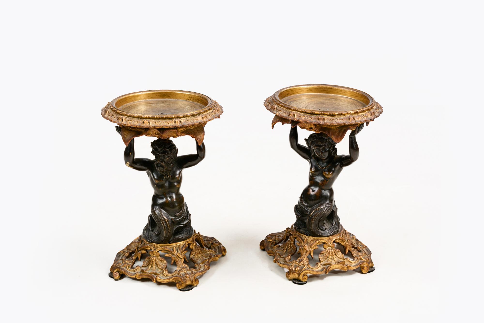 Paire de tazzas en bronze de style Régence du début du XIXe siècle, avec des tiges en forme du dieu grec Poséidon et de son épouse la déesse Amphitrite, supportant des plateaux en bronze doré et reposant sur des bases en bronze doré. C. 1820.