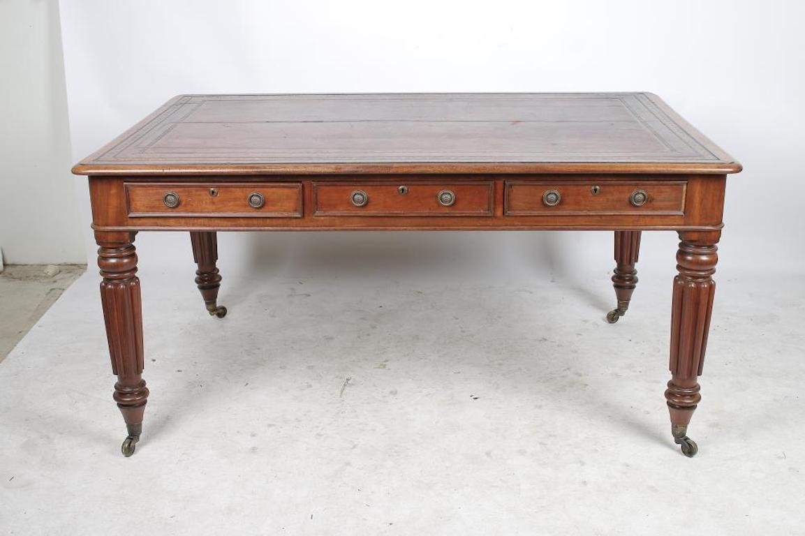 Early 19th century mahogany partners writing desk or library table. Reeded tapered Regency legs with three drawers in frieze on each side. Leather top

Beautiful wood figuring.