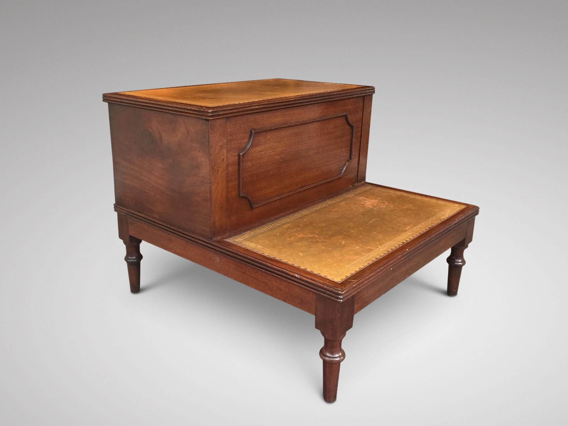 A set of early 19th century, Regency period mahogany and gold brown tooled leather two tier bed steps, standing on turned supports. comprising a small cupboard in top. England circa 1810. Great colour to mahogany and leather and lovely patina