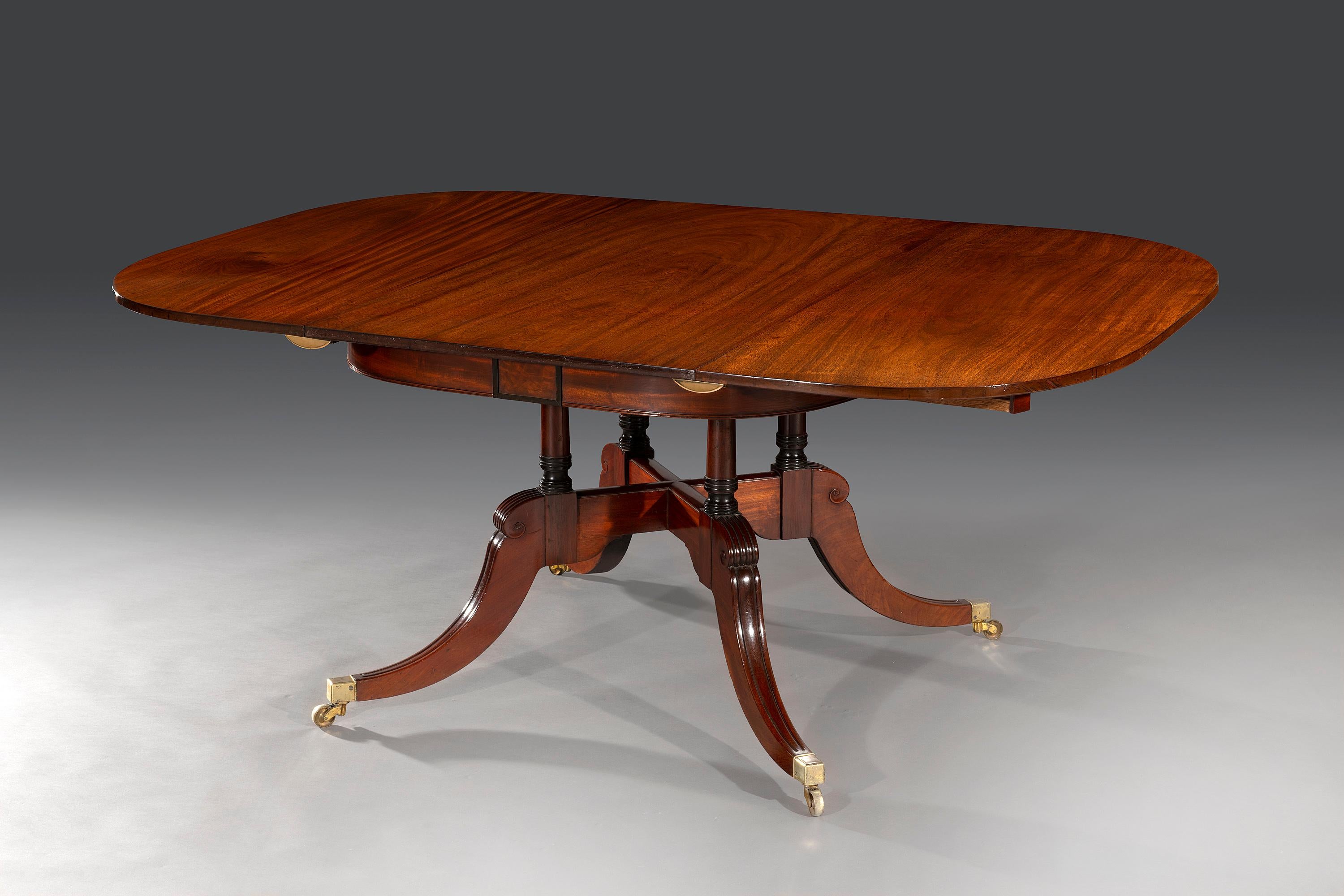 The mahogany top with rounded ends is well figured and opens to insert an additional mahogany leaf. The oak superstructure below is concealed and stamped with the makers impress mark, 'James Winter & Sons, Wardour Street, London'. The frieze centre