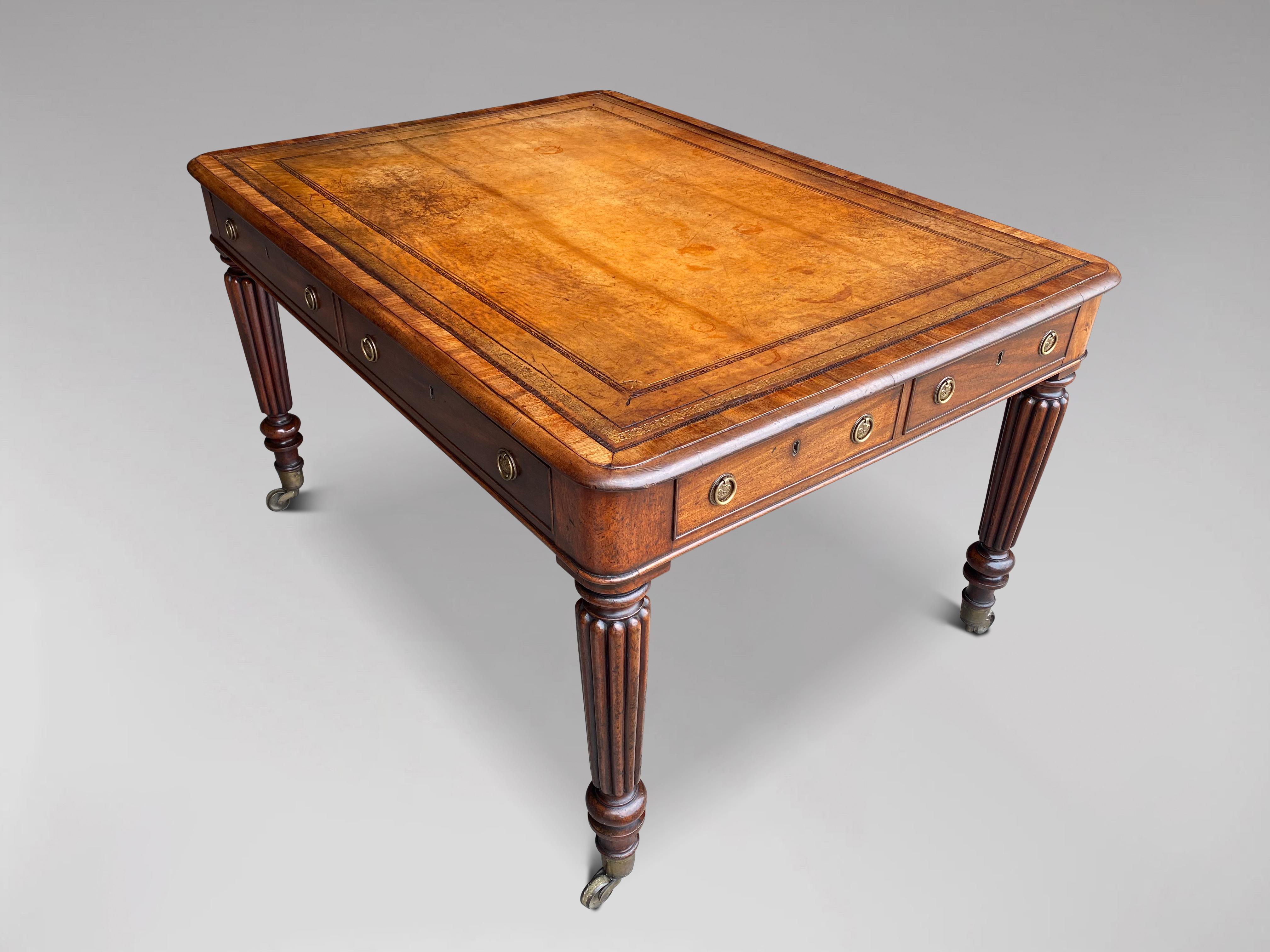 A fine early 19th century, Regency period mahogany partners library writing table. The rounded moulded rectangular top with superb quality light gold brown tooled leather inset top above 4 oak lined drawers with the original Prince of Wales feathers