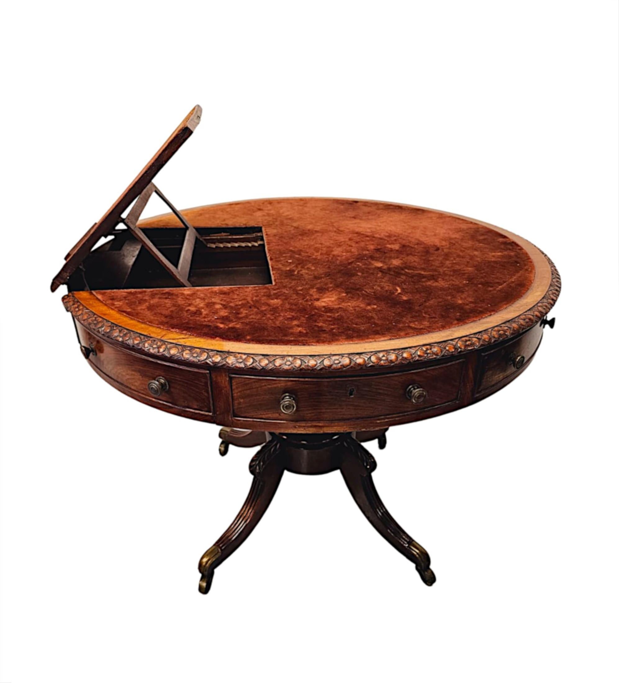 Un rarissimo tavolo da biblioteca a tamburo girevole in mogano ben figurato dell'inizio del XIX secolo.  Questo splendido pezzo è di qualità eccezionale e finemente intagliato a mano con una ricca patinatura e venatura.   Il piano sagomato di forma