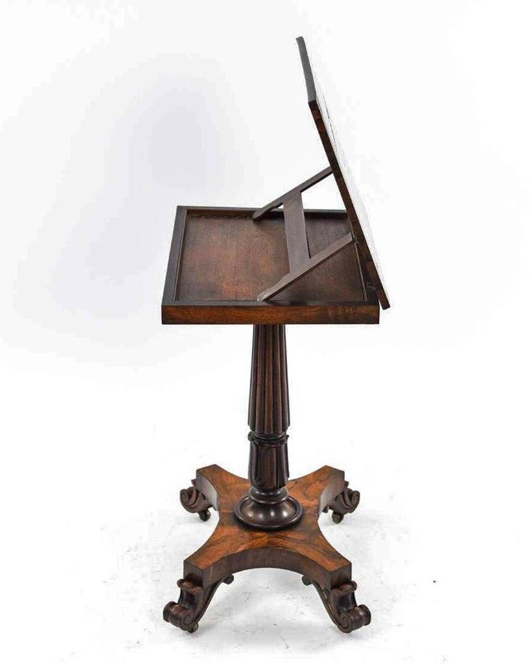 The early 19th century music manuscript stand is of the English Regency period and has a rosewood veneer. The bottom tips of an 