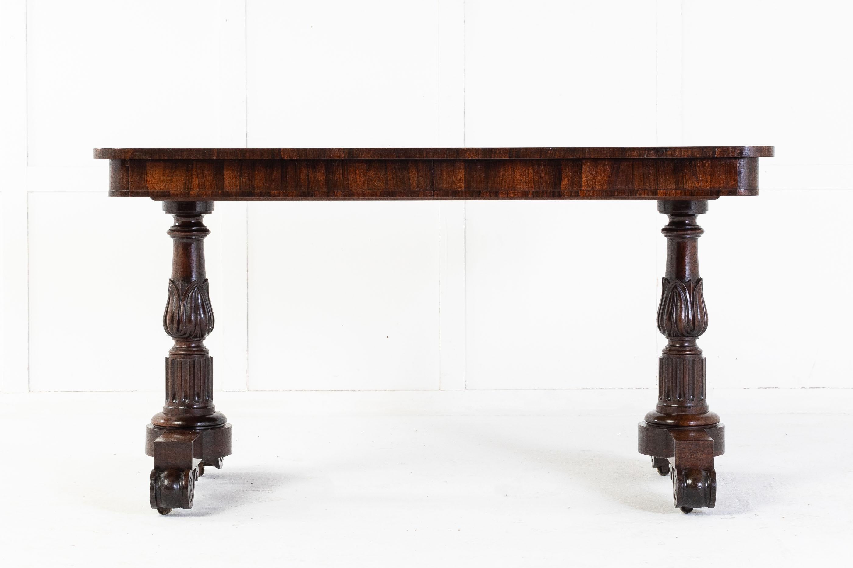 Early 19th century regency rosewood writing table attributed to Gillows.

A substantial quality rosewood desk with a top of choice veneer and two disguised draws. The top is supported by two, quality carved, end supports with deep fluting below